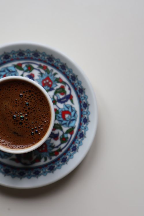 Free Overhead view of Turkish coffee in a colorful floral cup and saucer on white background. Stock Photo