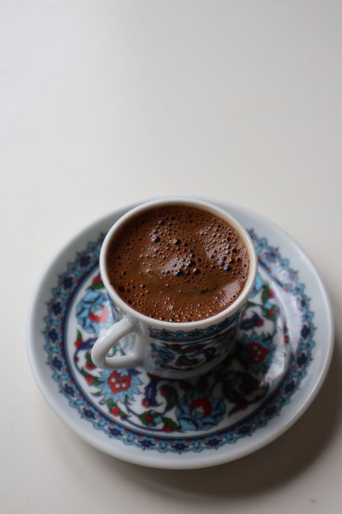 Free A close-up view of traditional Turkish coffee served in a decorative cup on a matching saucer. Stock Photo