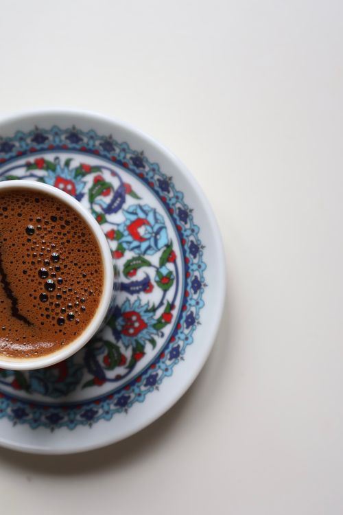 Free High-angle view of Turkish coffee in an ornate cup on a decorative plate. Stock Photo