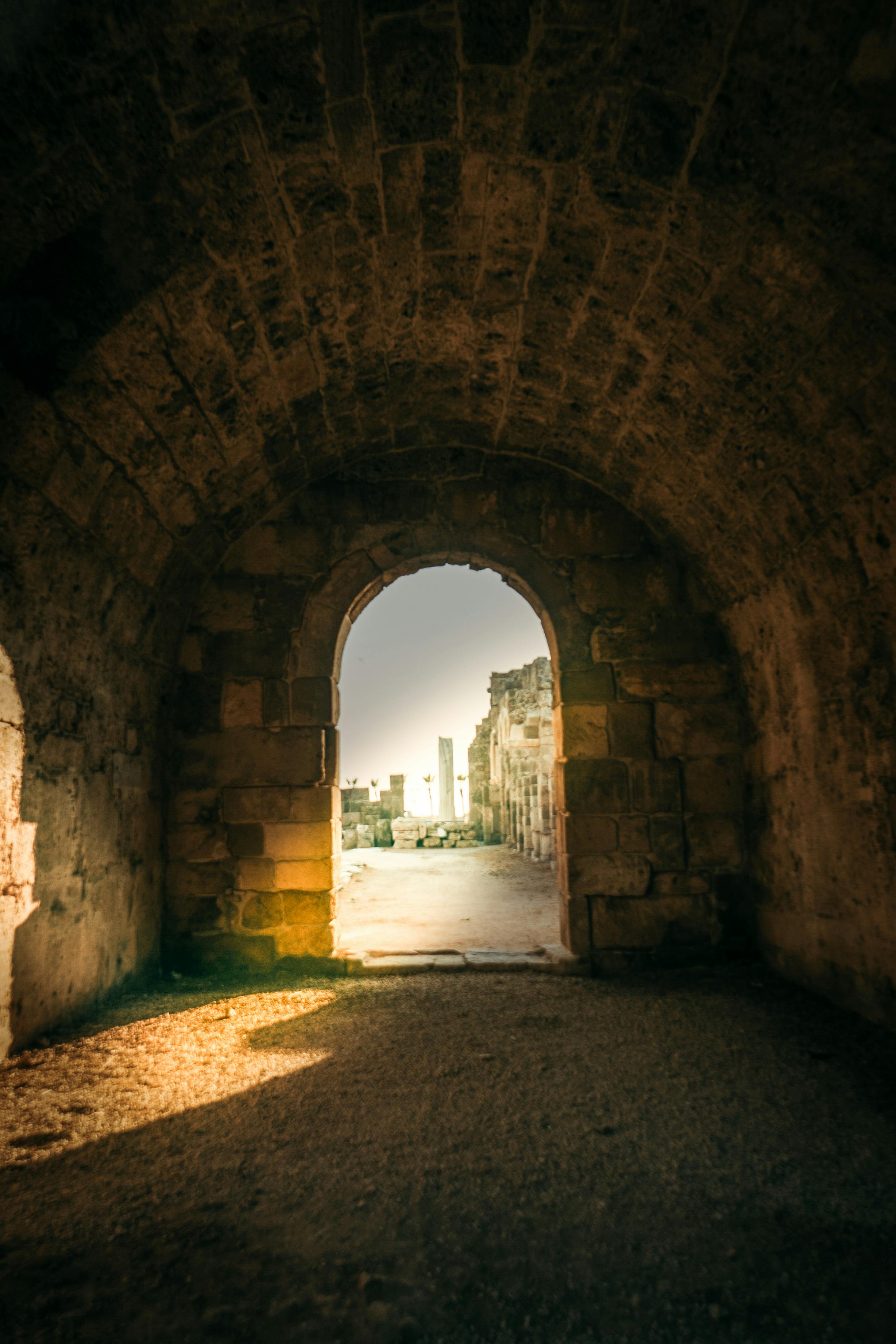 Gratis Vista attraverso un antico arco che conduce alle rovine di Side, Antalya, Turchia, immerso in una calda luce solare. Foto a disposizione