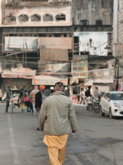 Free Man walking in Amritsar's lively street market with traditional attire, showcasing daily Indian life. Stock Photo
