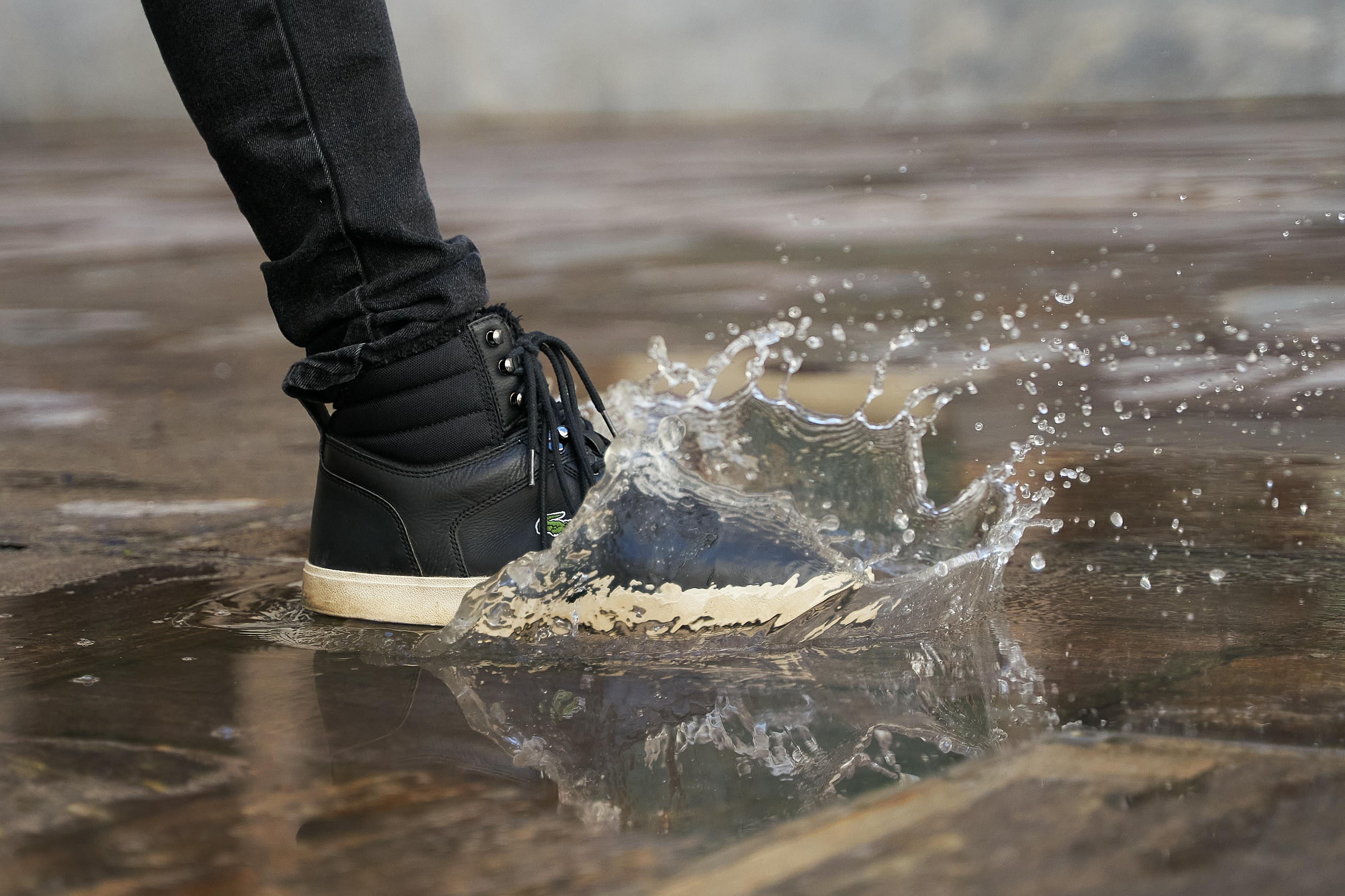 gratis Leg een plons in stijl vast met deze foto van een laars die in een plas trapt in Graz, Oostenrijk. Stockfoto
