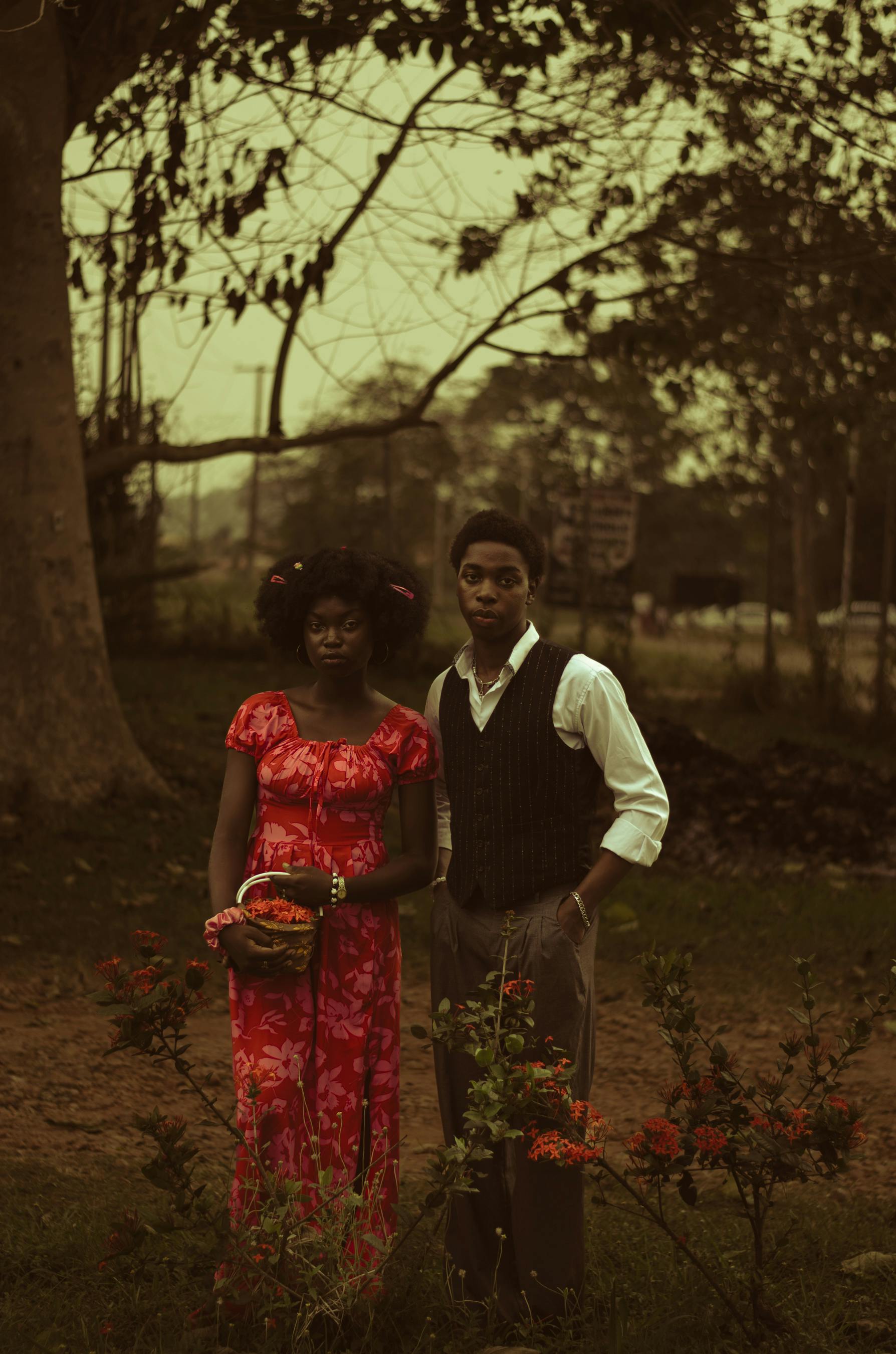 免费 一张复古风格的肖像照，拍摄对象是一对年轻夫妇在花园里，捕捉到了宁静而经典的尼日利亚风情。 素材图片