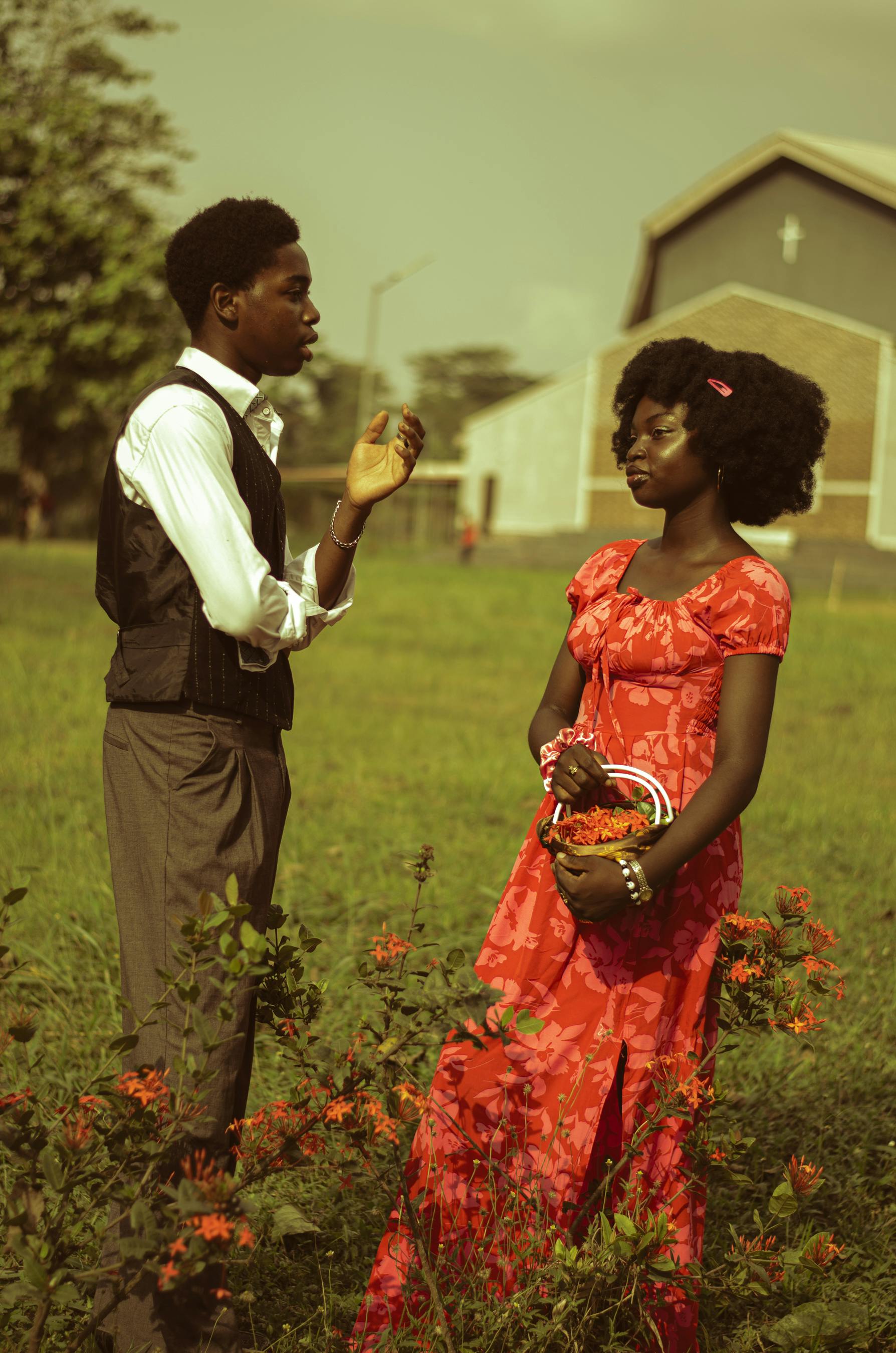bezplatná Mladý pár ve formálním oblečení si venku v Gaga v Nigérii, obklopený zářivou vegetací, povídá. Základová fotografie