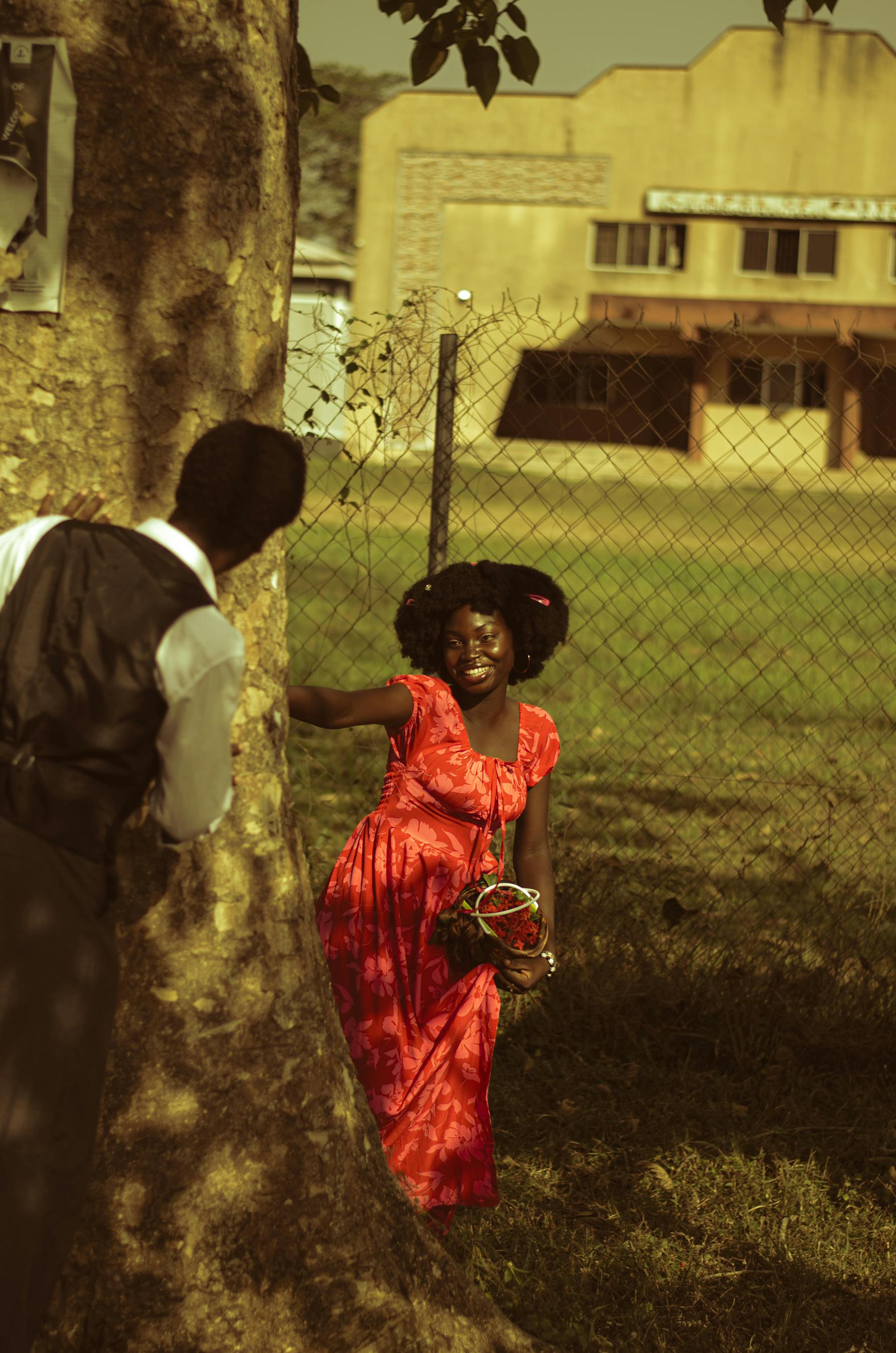 Miễn phí Một cặp đôi đang vui đùa tương tác quanh một cái cây trong khung cảnh ngoài trời ở Nigeria. Ảnh lưu trữ