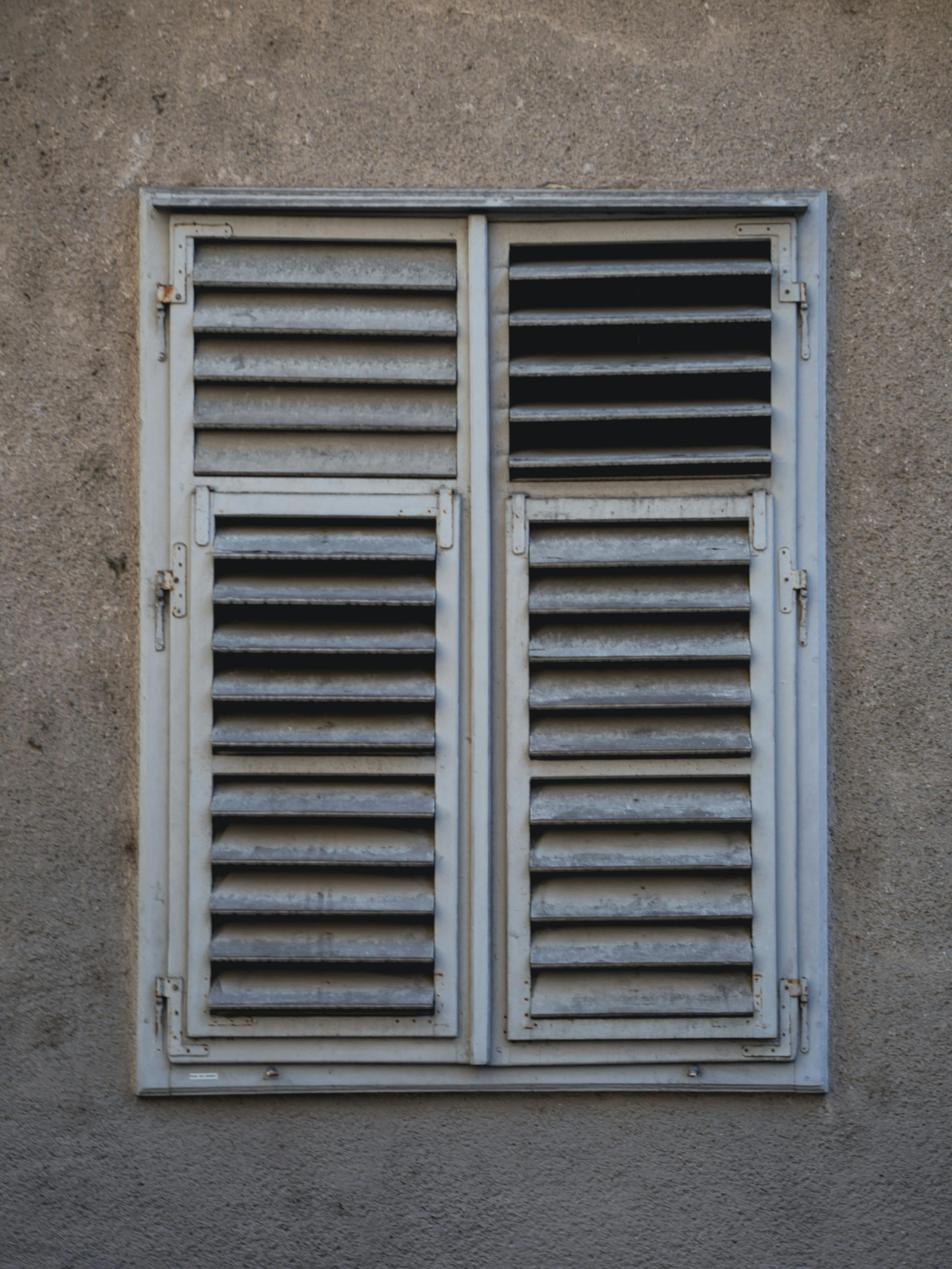 Gratis Rustikke vinduesskodder på en gammel bygningsfacade i Graz, Østrig, der viser en unik arkitektonisk stil. Lagerfoto