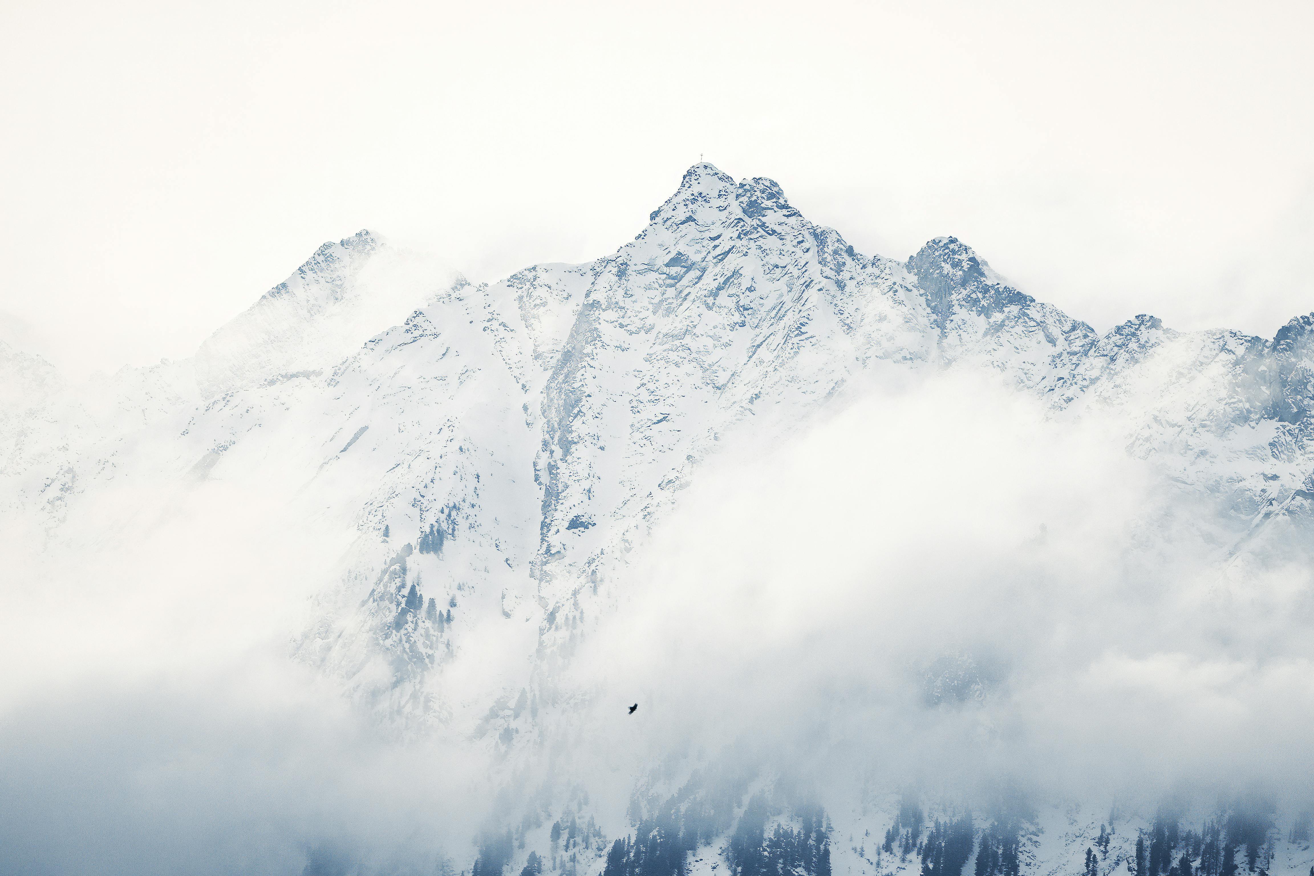 無料 雲に一部隠れた、雪をかぶった山々の峰々の息を呑むような絶景。 写真素材