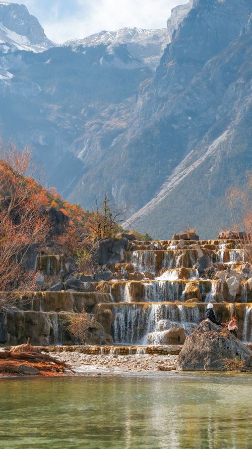 Free Beautiful waterfall cascading in the mountains of Lijiang, China, under a clear sky. Stock Photo