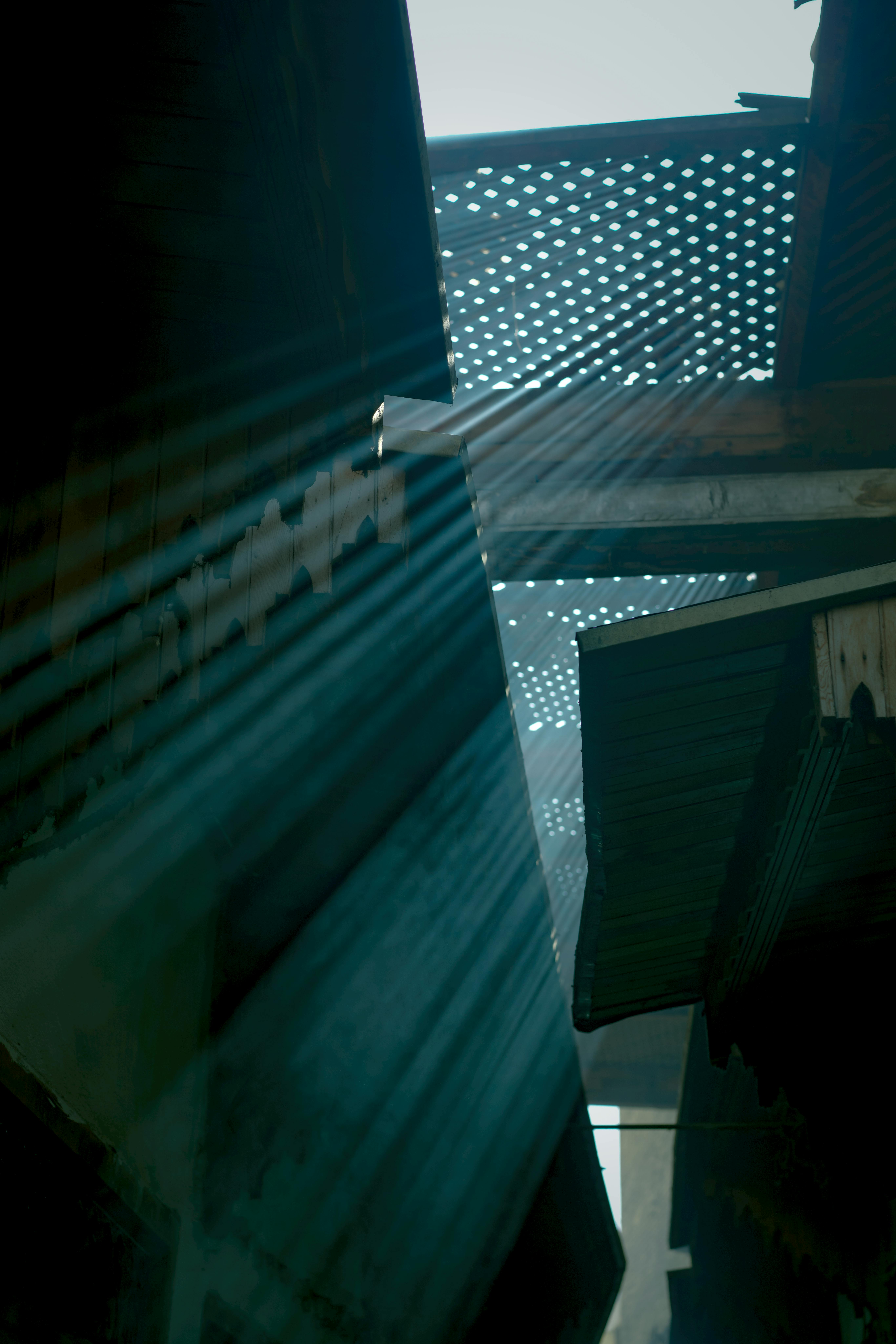 Kostnadsfria Solstrålar som strömmar genom perforerade tak i en smal gränd och skapar en lugn och konstnärlig atmosfär. Stock foto