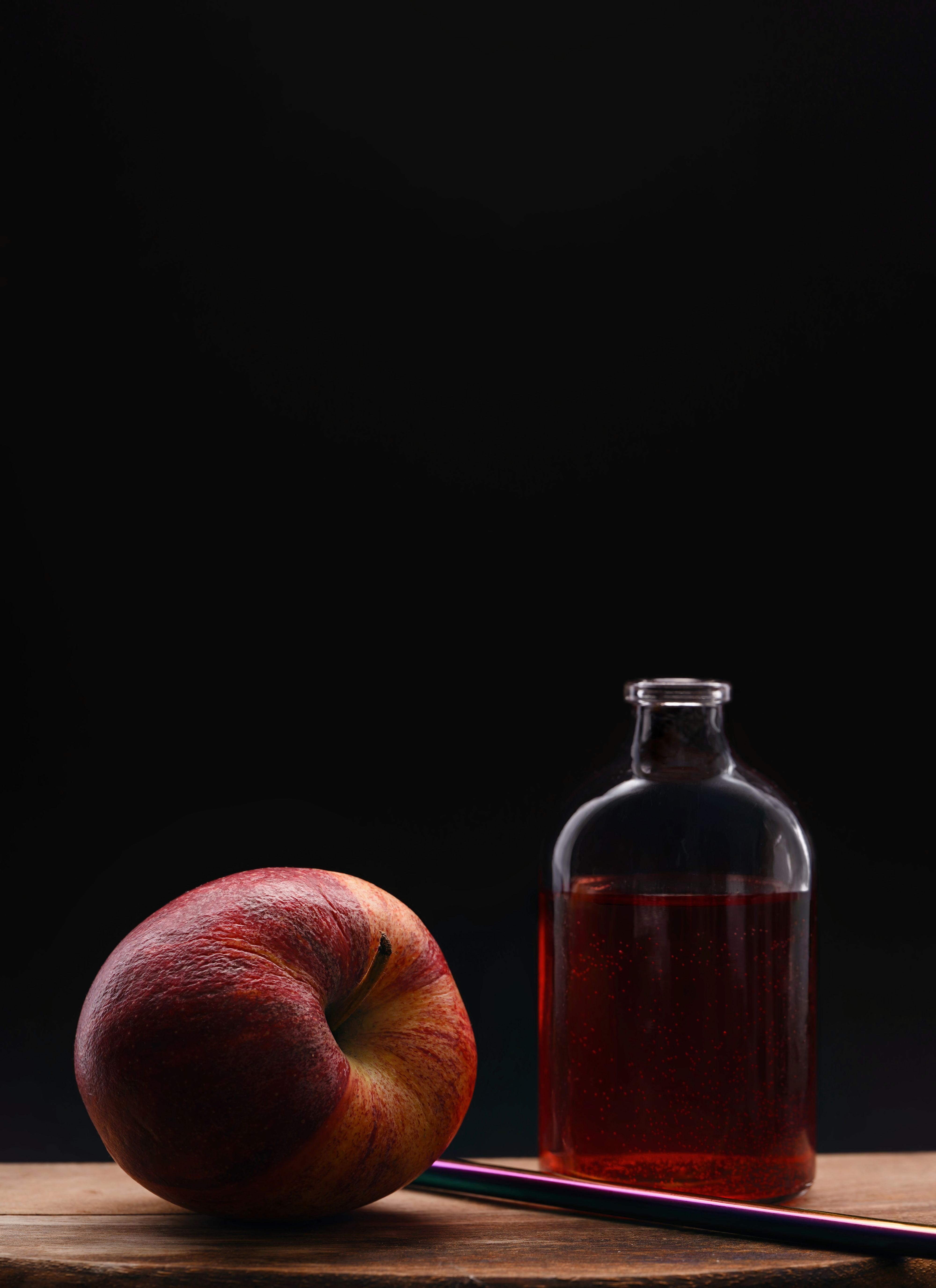 Elegant still life of apple and bottle, perfect for culinary and artistic themes.