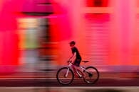 Cyclist Riding Fast in Vibrant Pink Urban Setting