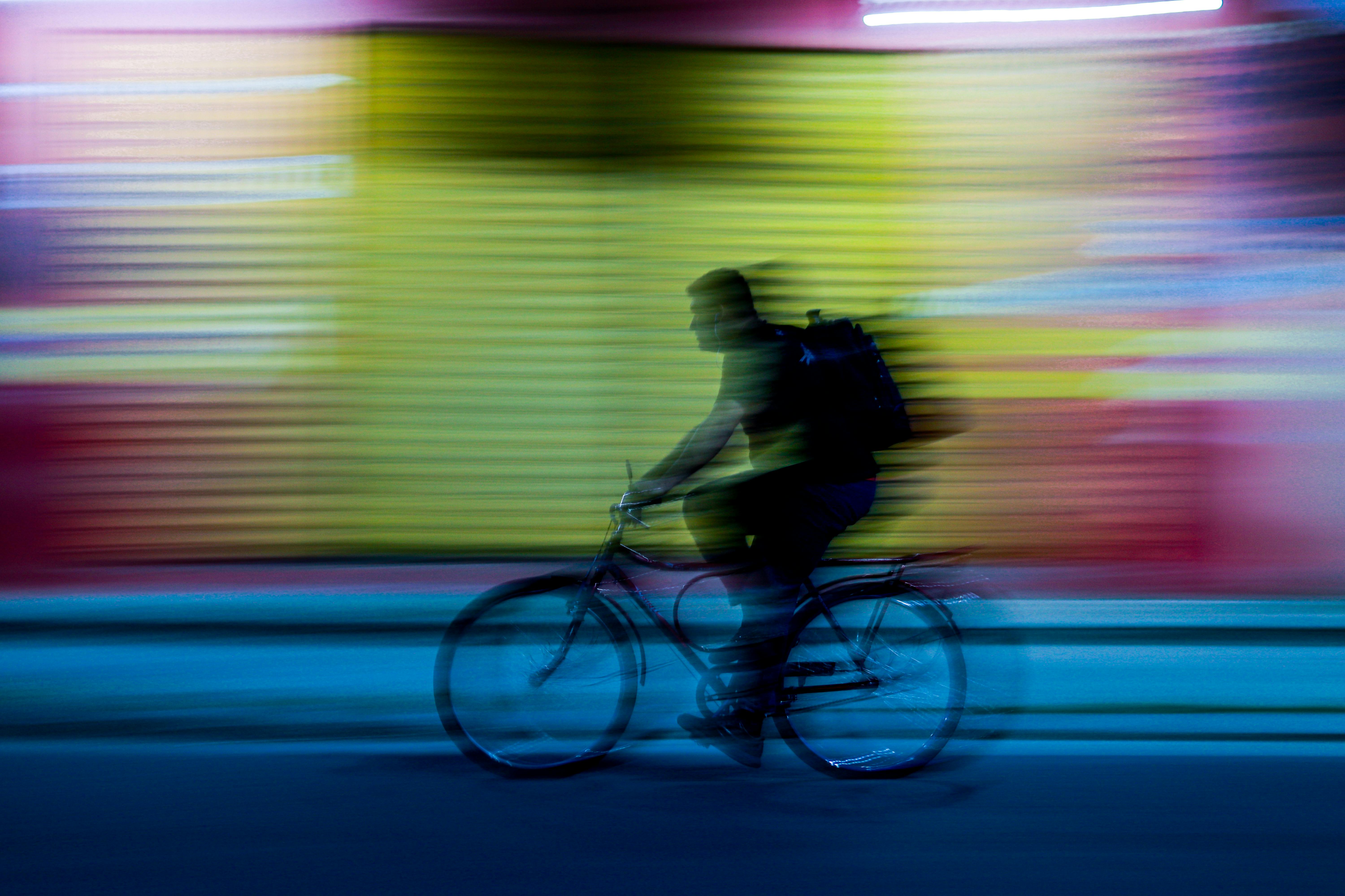 Gratis Effetto mosso dinamico di un ciclista che pedala di notte a Parintins, in Brasile, creando scie colorate e vibranti. Foto a disposizione