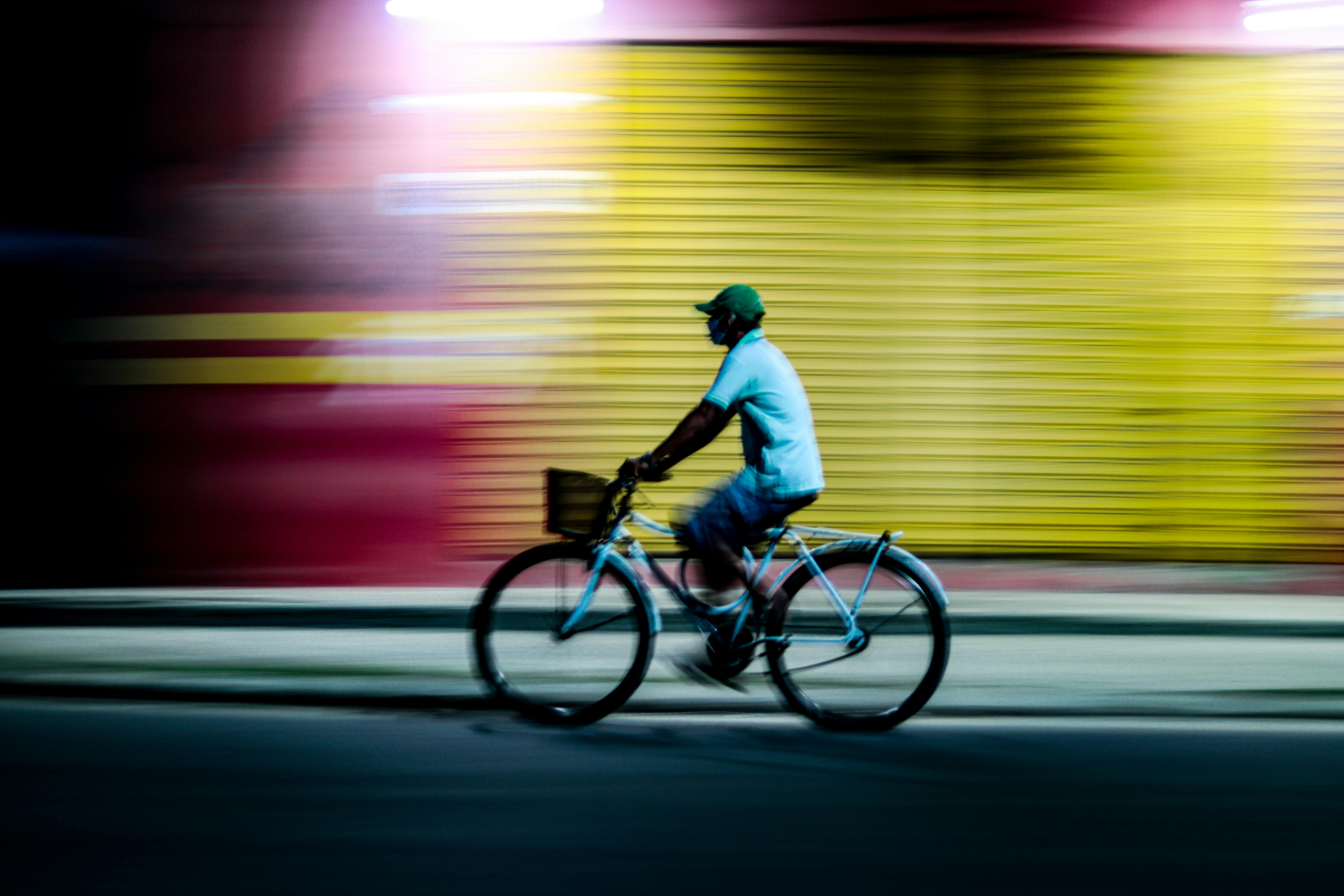 Gratuit Un biciclist trece cu viteză pe lângă un peisaj urban colorat noaptea în Parintins, Brazilia. Este surprinsă o estompare vibrantă și dinamică a mișcării. Fotografie de stoc