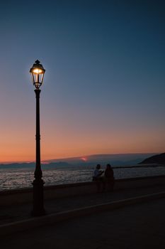 Silhouettes by the sea at sunset in Santa Maria di Castellabate, Campania, Italy.