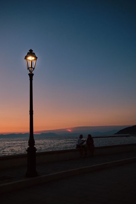 Silhouettes by the sea at sunset in Santa Maria di Castellabate, Campania, Italy.