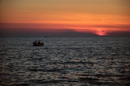 Free Silhouette of a boat at sunset in Santa Maria di Castellabate, Italy, capturing the serene beauty of the sea. Stock Photo