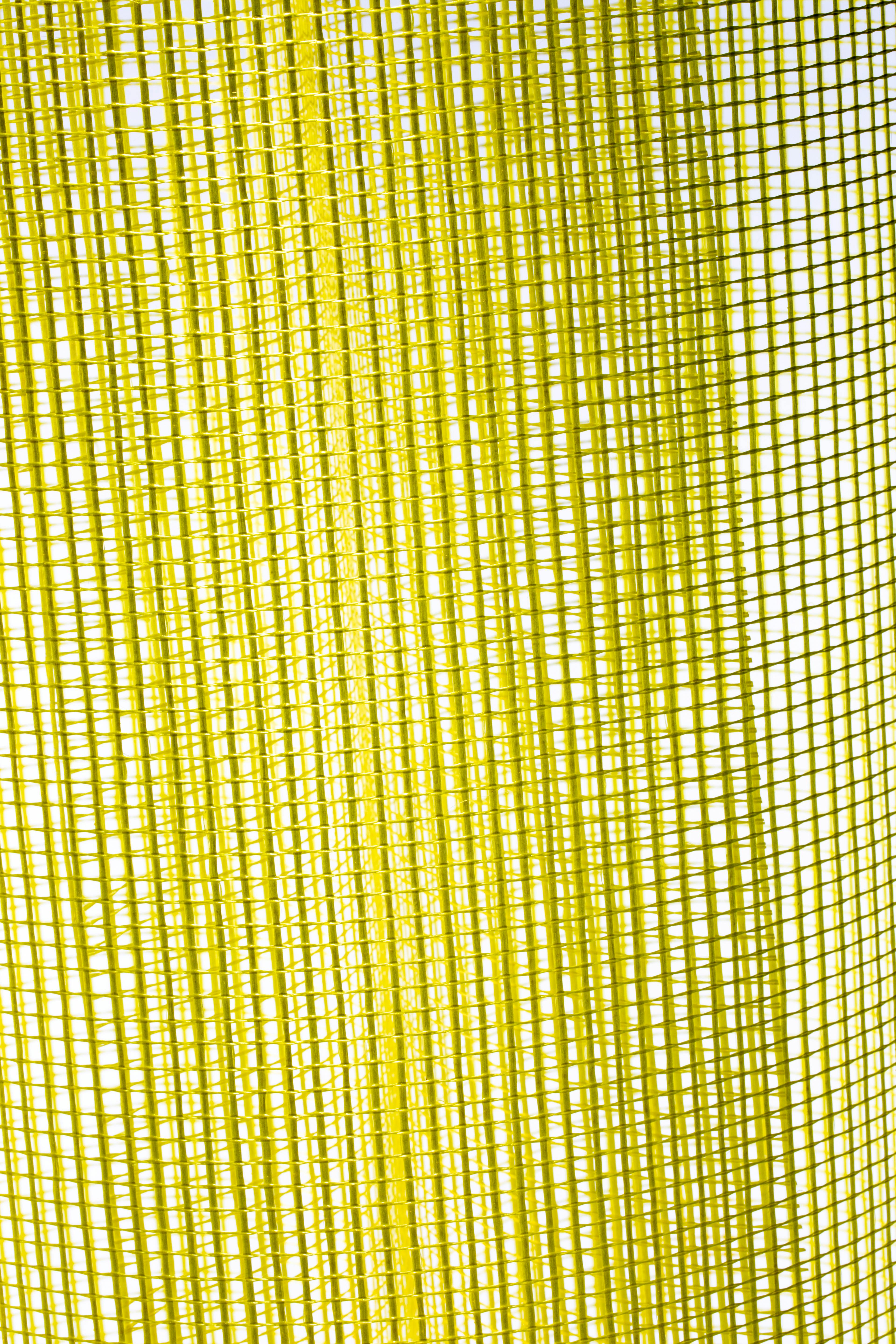 ingyenes Közeli kép egy sárga hálós anyag textúrájáról, amely bonyolult geometriai mintákat mutat be élénk, absztrakt stílusban. Stockfotó