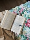 Open Book on Floral Bedspread with Soft Light