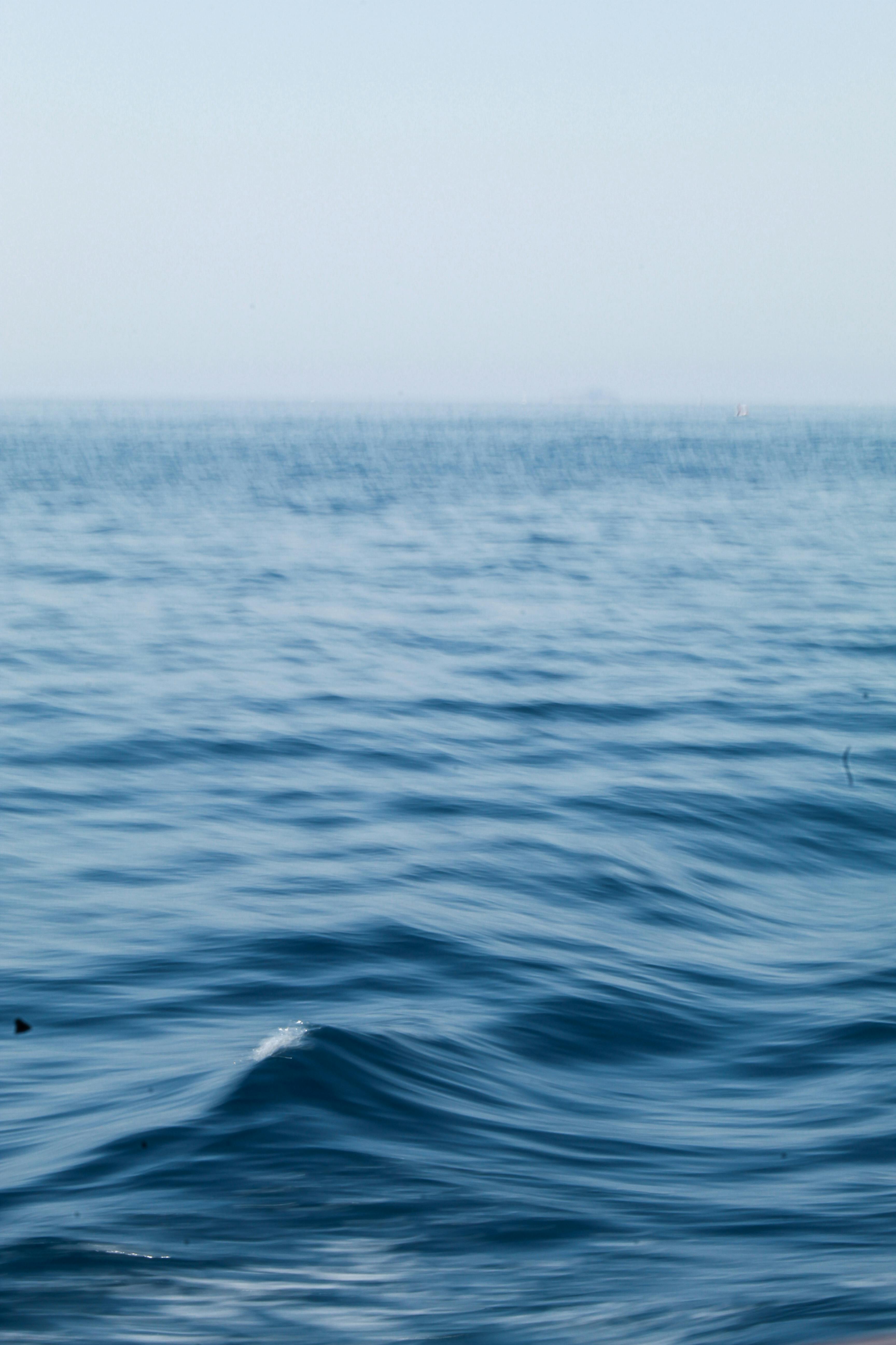 Gratuit Paysage océanique serein avec des vagues douces et un ciel bleu clair, parfait pour les thèmes de détente. Photos