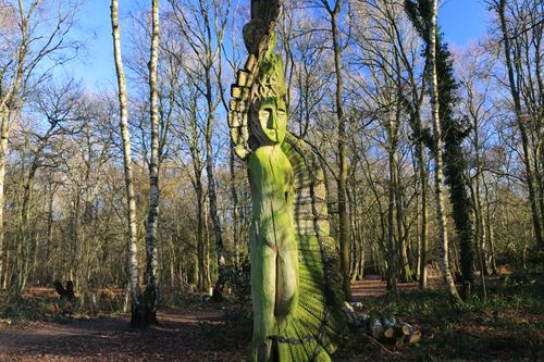 Free Artistic tree sculpture of the Green Man in an English forest during winter. Stock Photo