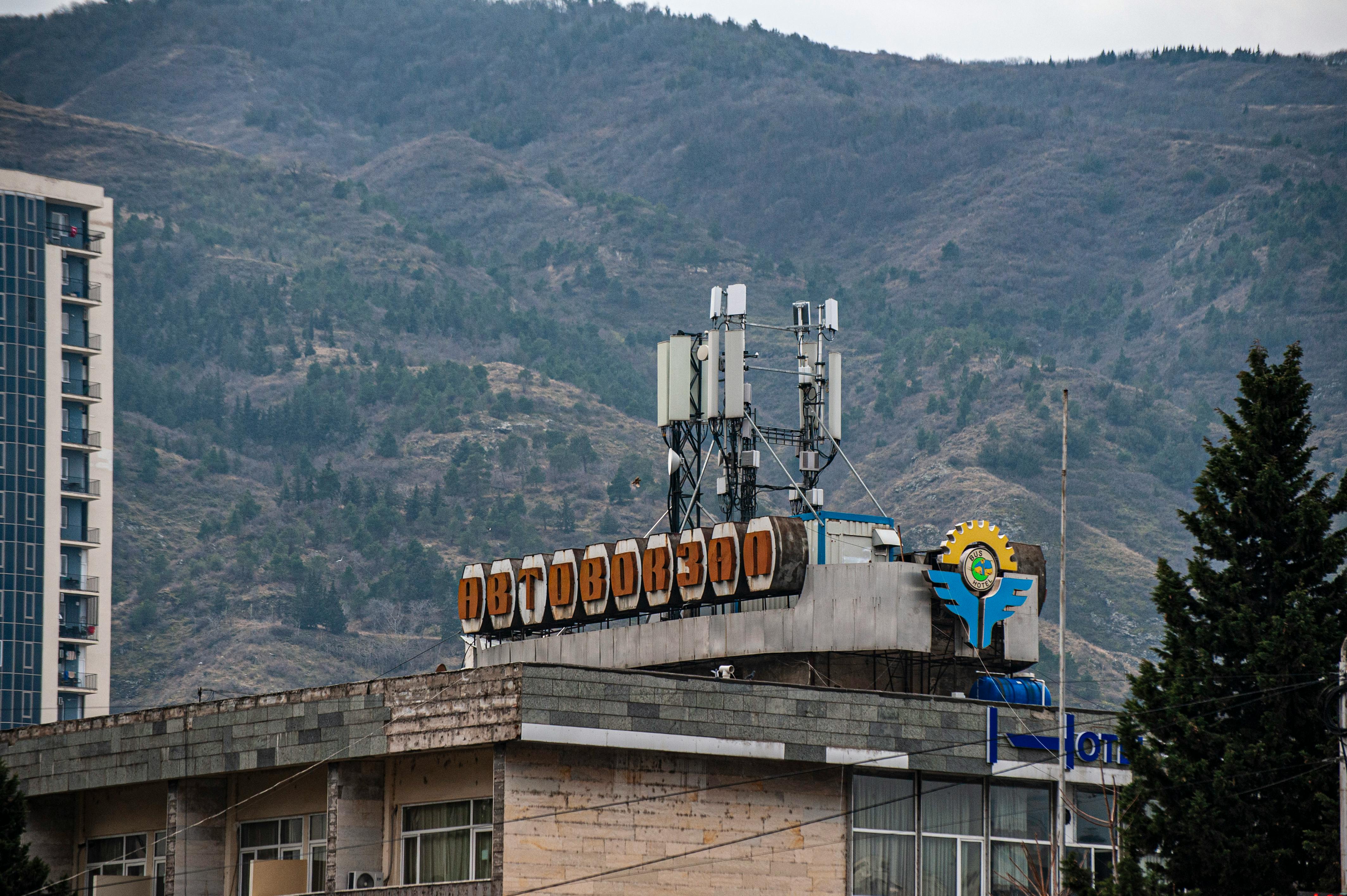 Kostnadsfria Stadslandskap med en byggnad med rysk skrift och berg i bakgrunden, Georgien. Stock foto