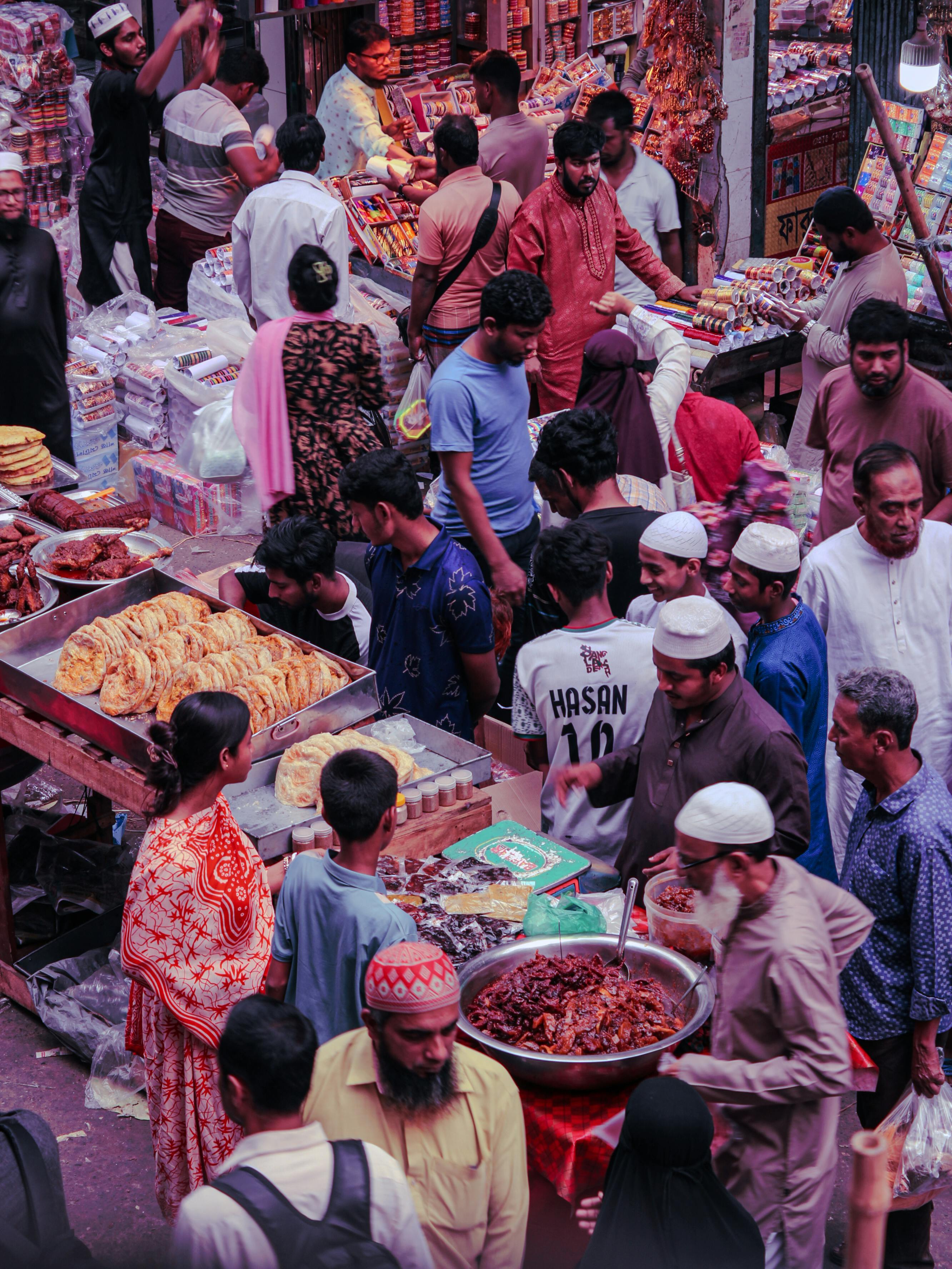 Busy street market scene with diverse shoppers and vendors in a lively atmosphere.