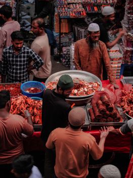 Bustling market with diverse street food vendors and customers engaging in a lively ambiance.