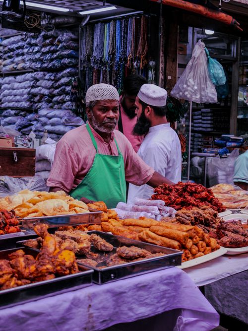 Free A street vendor in a vibrant market setting selling diverse fried foods. Stock Photo