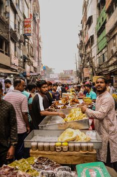 Busy street market scene with vendors selling food and vibrant crowd.