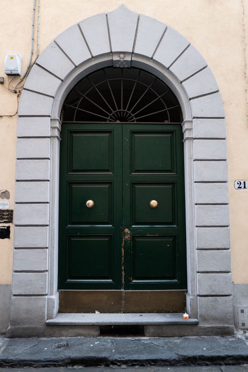 Free Charming green arched doorway with classic stone frame in Trastevere, Rome. Stock Photo
