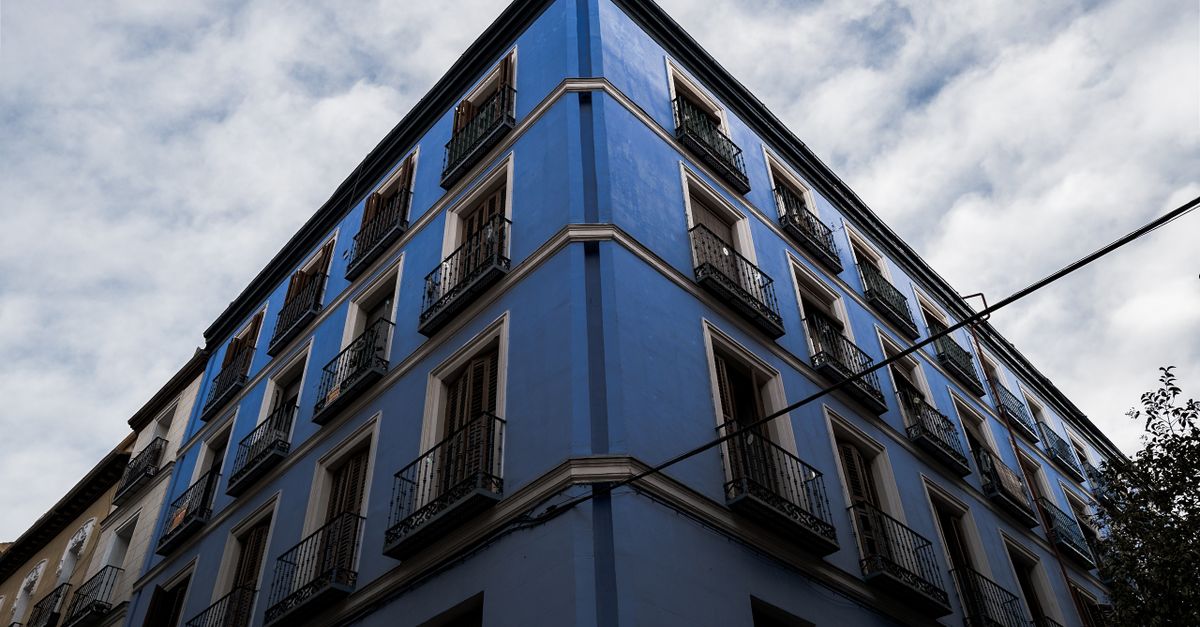 Vista desde un ángulo espectacular de un edificio de apartamentos de un azul vibrante en Madrid.