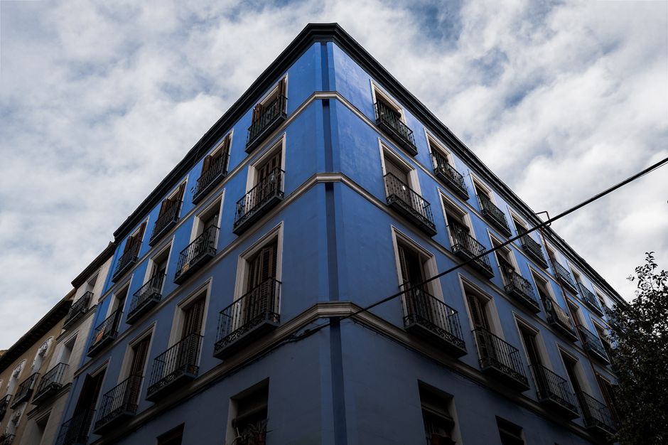 Vista desde un ángulo espectacular de un edificio de apartamentos de un azul vibrante en Madrid.