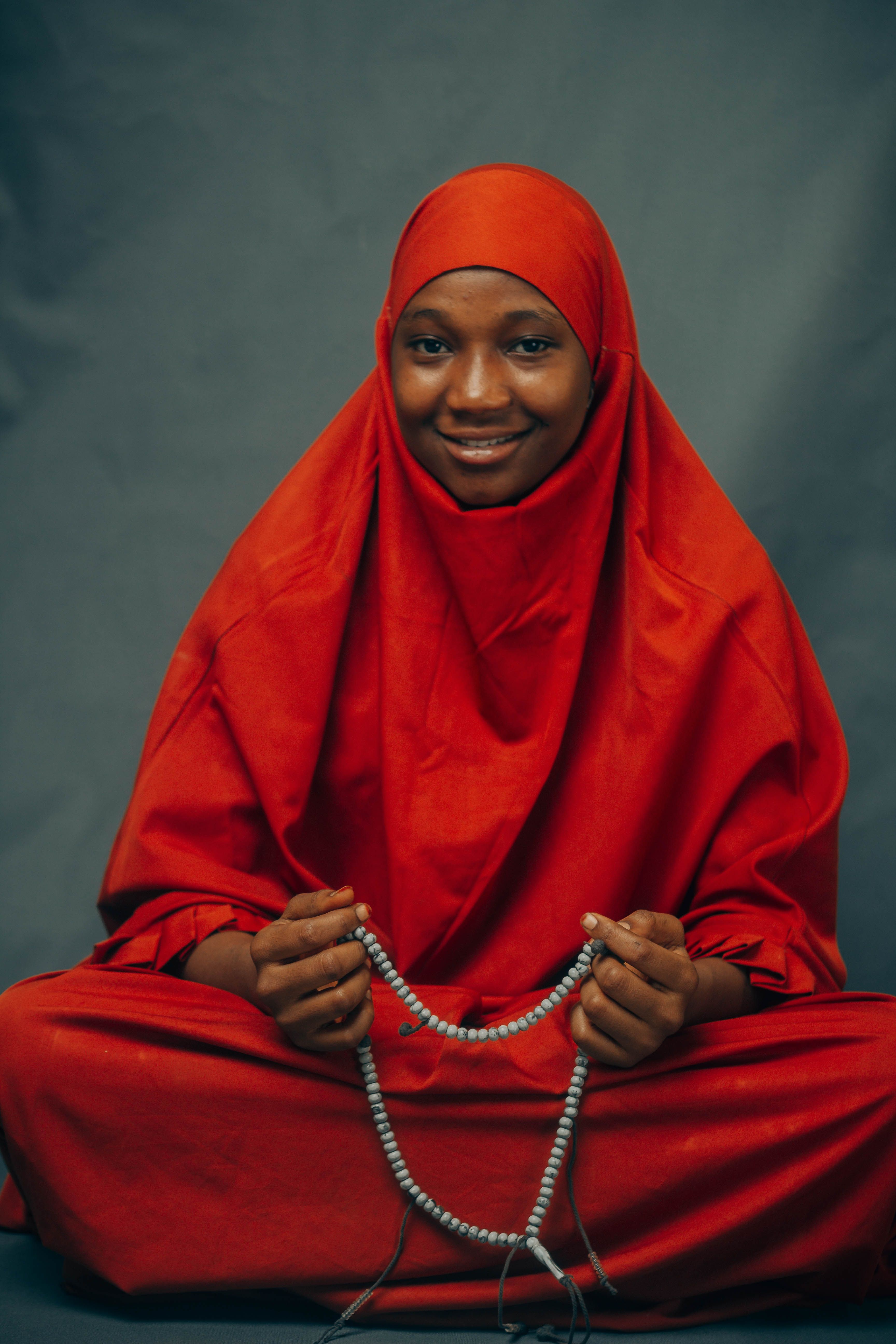 Portrait D'une Femme Portant Un Hijab Rouge Et Un Chapelet · Photo gratuite