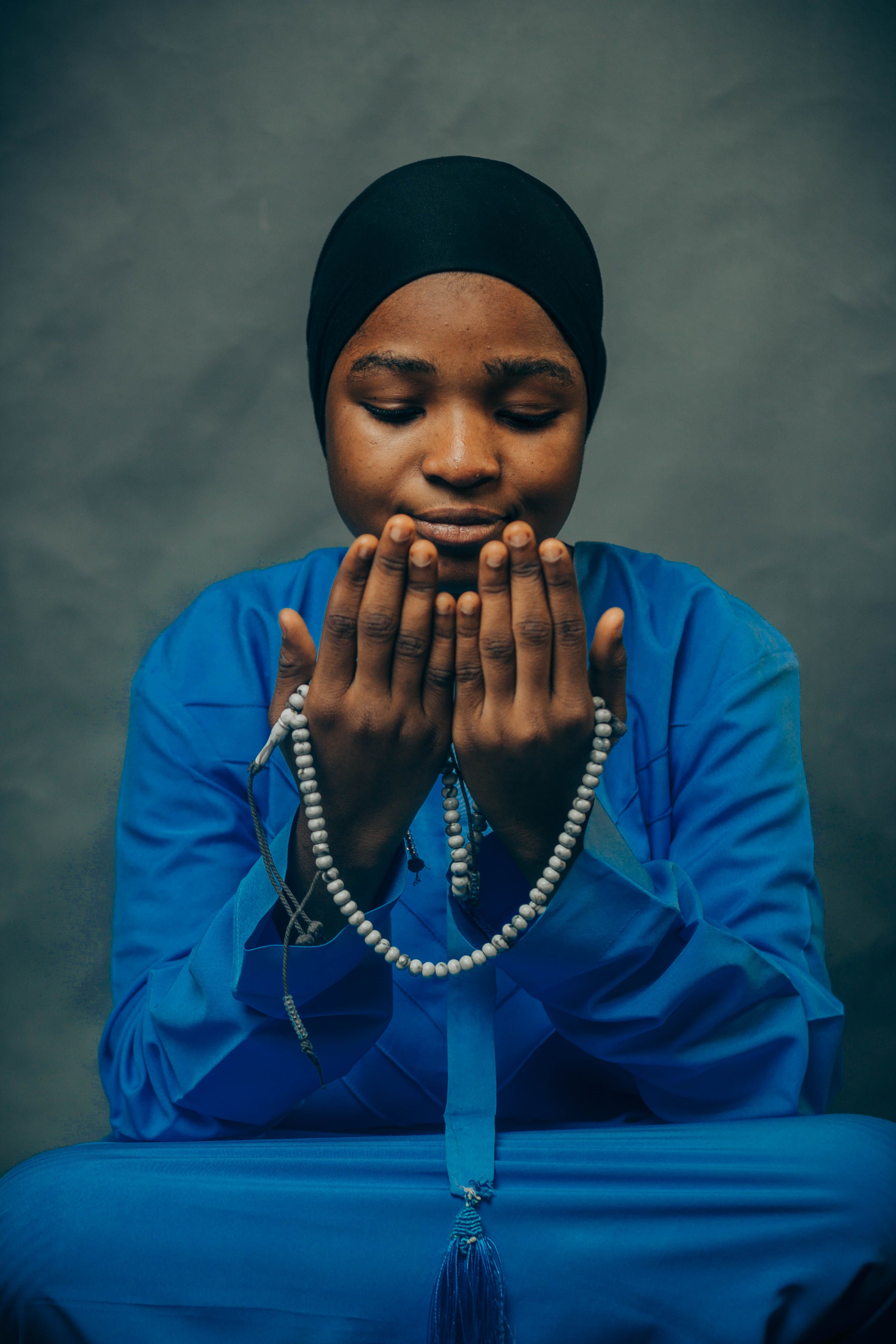 Person in Traditional Attire Holding Prayer Beads · Free Stock Photo
