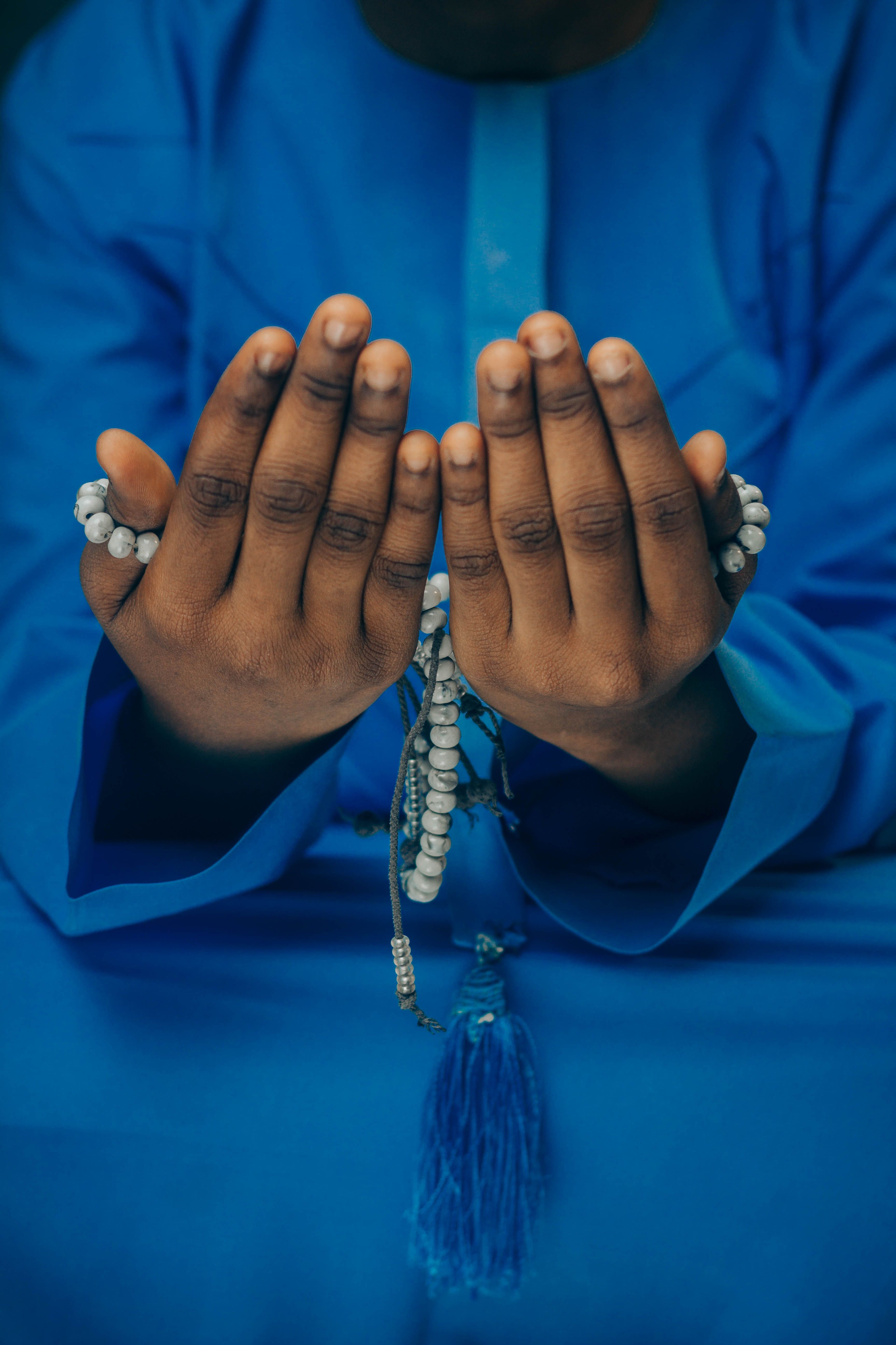 Person in Traditional Attire Holding Prayer Beads · Free Stock Photo
