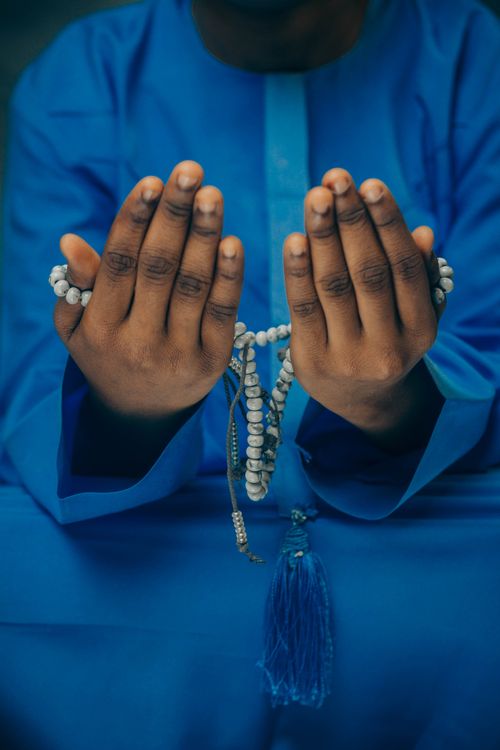 Person in Traditional Attire Holding Prayer Beads · Free Stock Photo