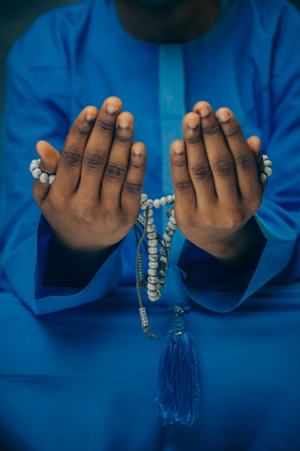 Person in Traditional Attire Holding Prayer Beads · Free Stock Photo