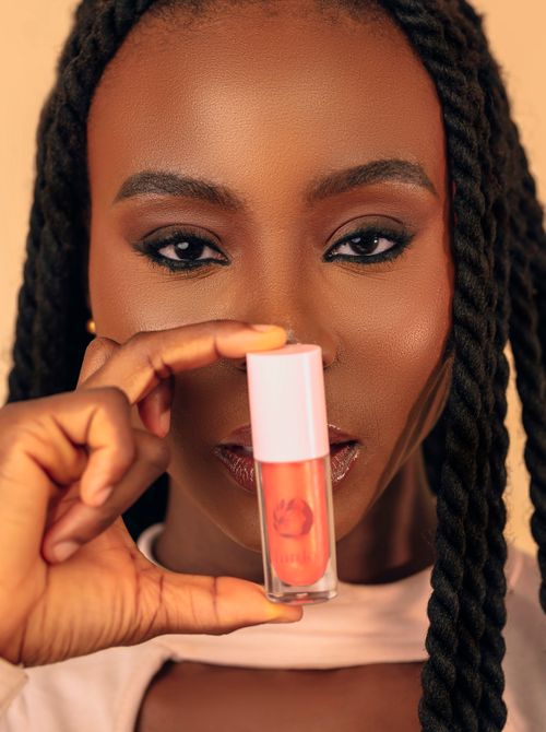 Free Beautiful woman holding a glossy lipstick in hand, close-up view. Stock Photo