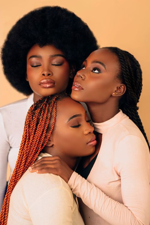 Free A close-knit trio of women embracing, exuding unity and serenity. Stock Photo