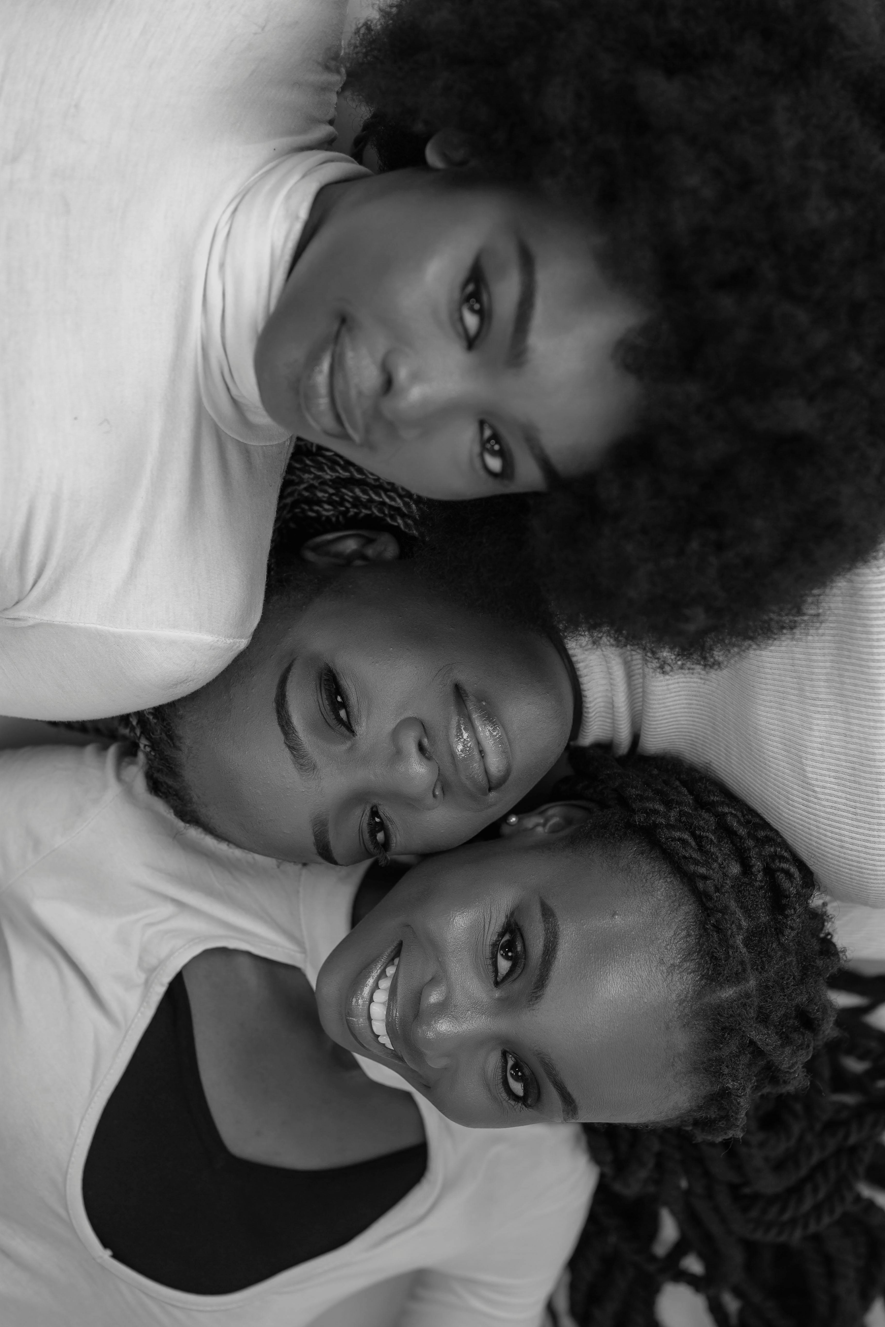 De franc Elegant retrat en blanc i negre que mostra tres dones somrients abraçant-se. Foto d'estoc