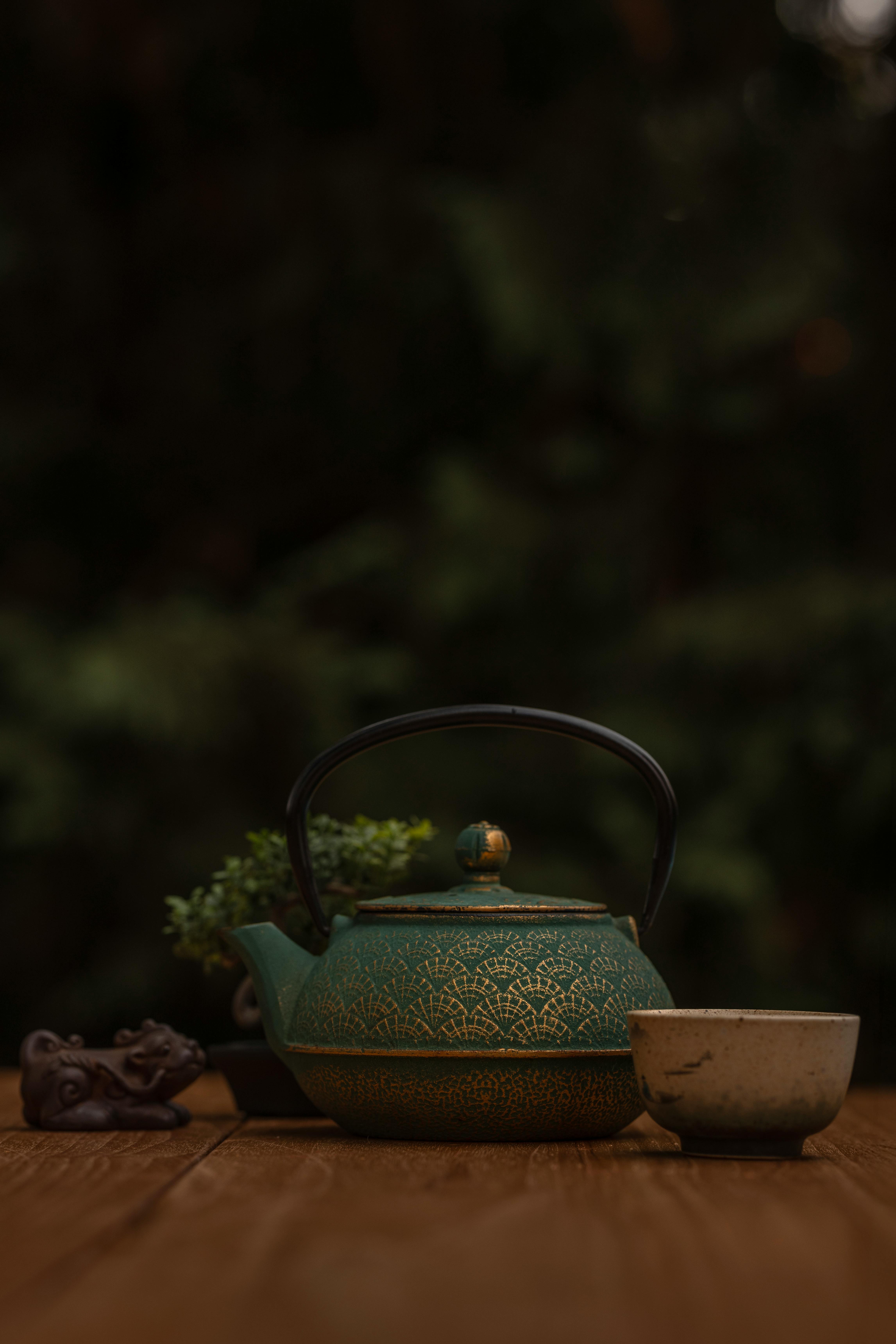 Gratis Una preciosa tetera de cerámica verde con una taza sobre una mesa de madera, perfecta para la hora del té. Foto de stock