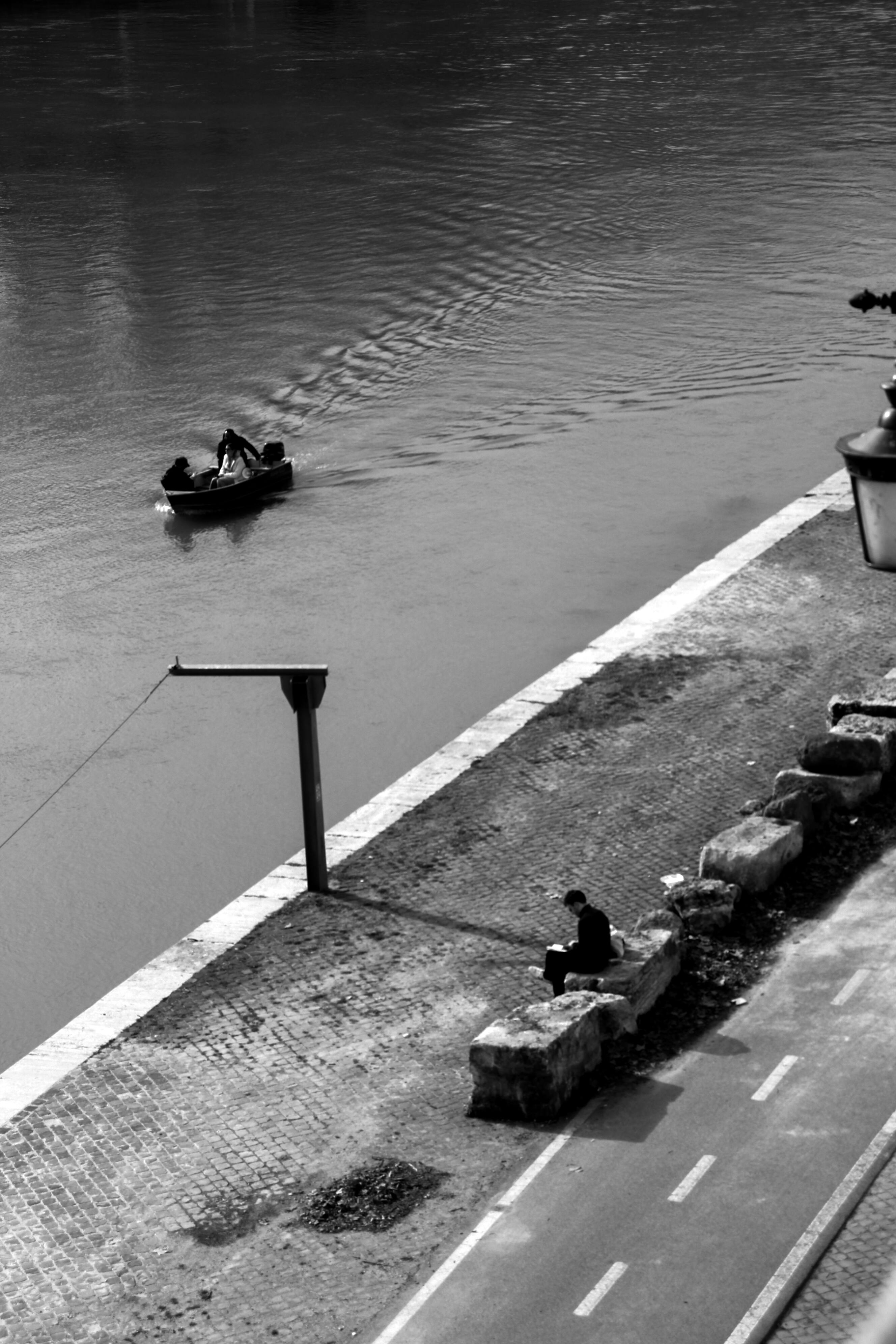 Zadarmo Monochromatický obraz lode v Ríme s osobou sediacou na brehu rieky, zachytávajúci pokoj. Fotka z fotobanky