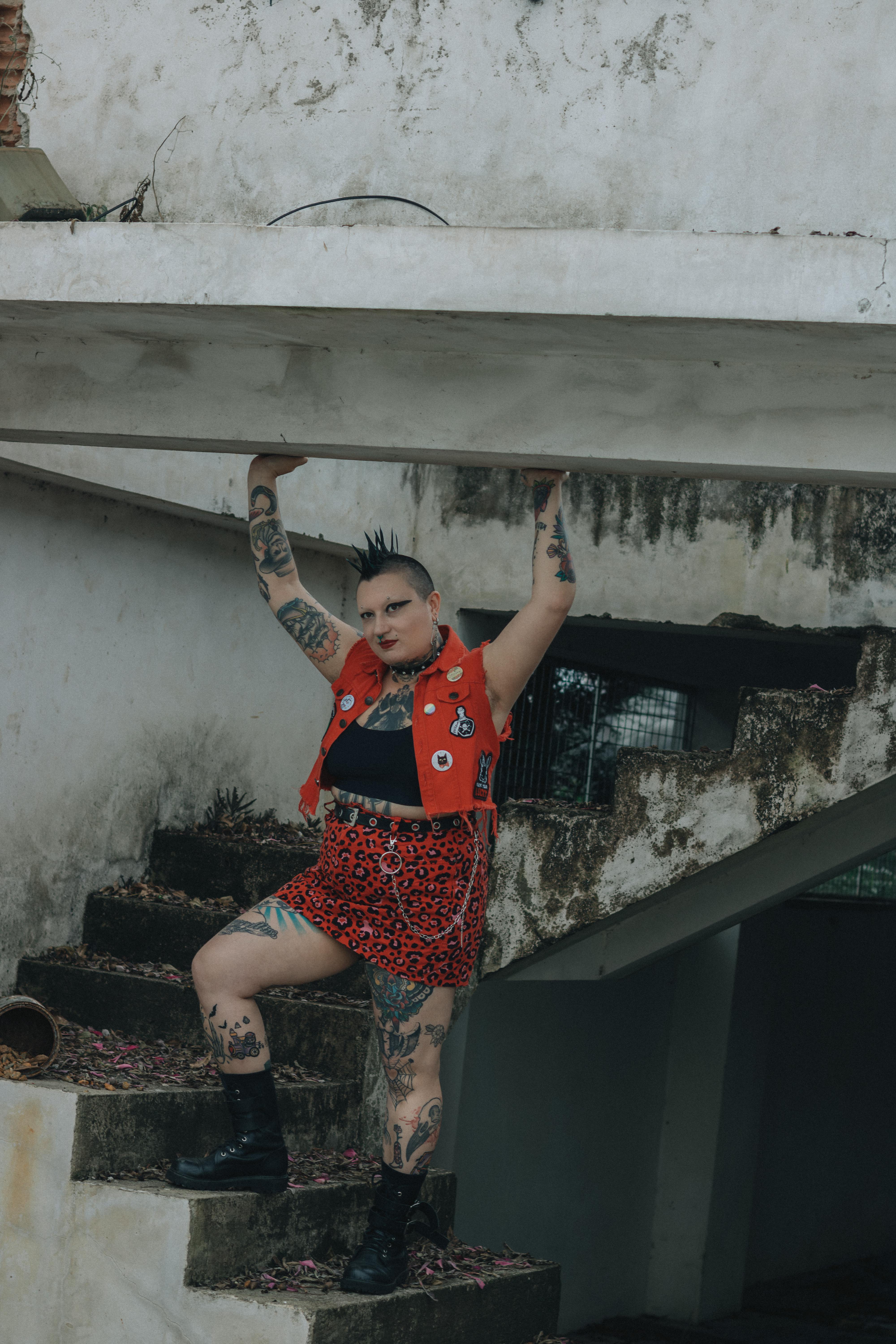 Ücretsiz Punk tarzı giyinen ve dövmeleri olan bir kişi, şehir ortamında poz vererek sıra dışı tarzını sergiliyor. Stok Fotoğraflar