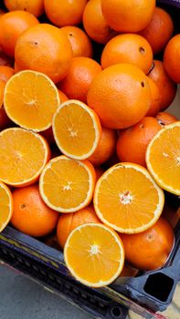 Bright, juicy oranges on display at a market stall, showcasing freshness and vibrant color.