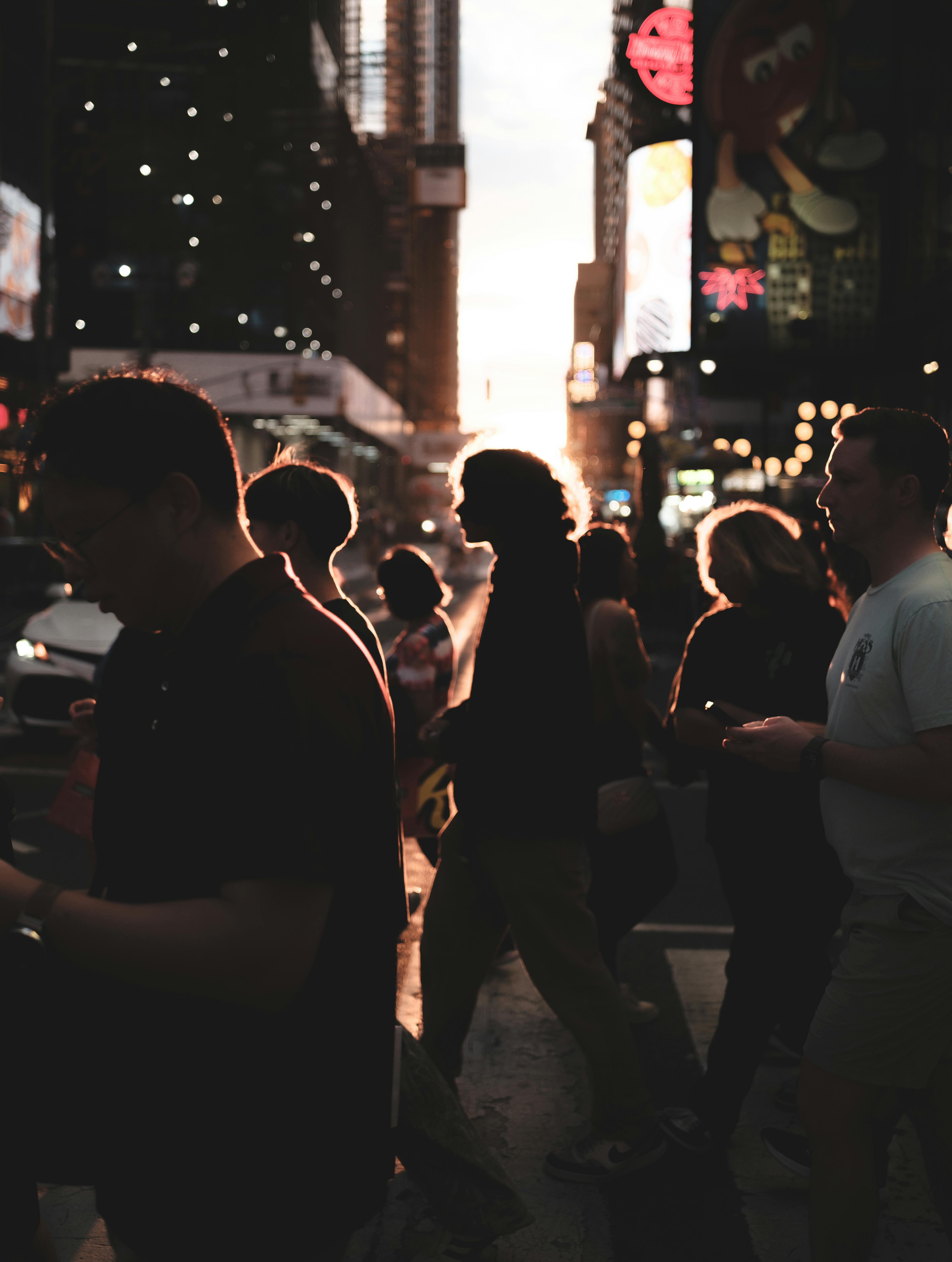 Zadarmo Chodci v siluete prechádzajúci cez Times Square za súmraku, zachytávajúci živú večernú atmosféru mesta. Fotka z fotobanky
