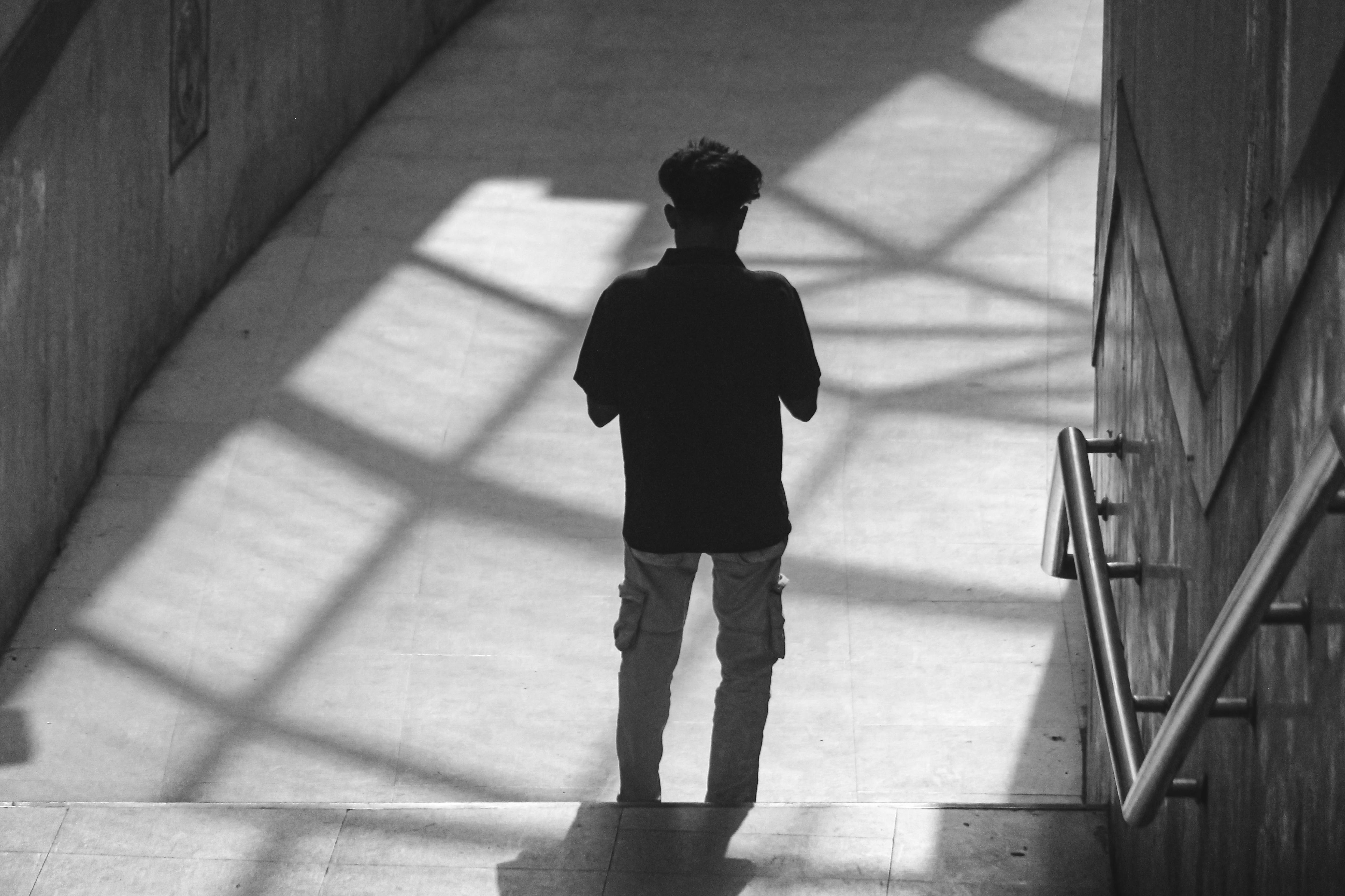 Gratuit Siluetă alb-negru a unui bărbat care coboară o scară urbană cu umbre. Fotografie de stoc