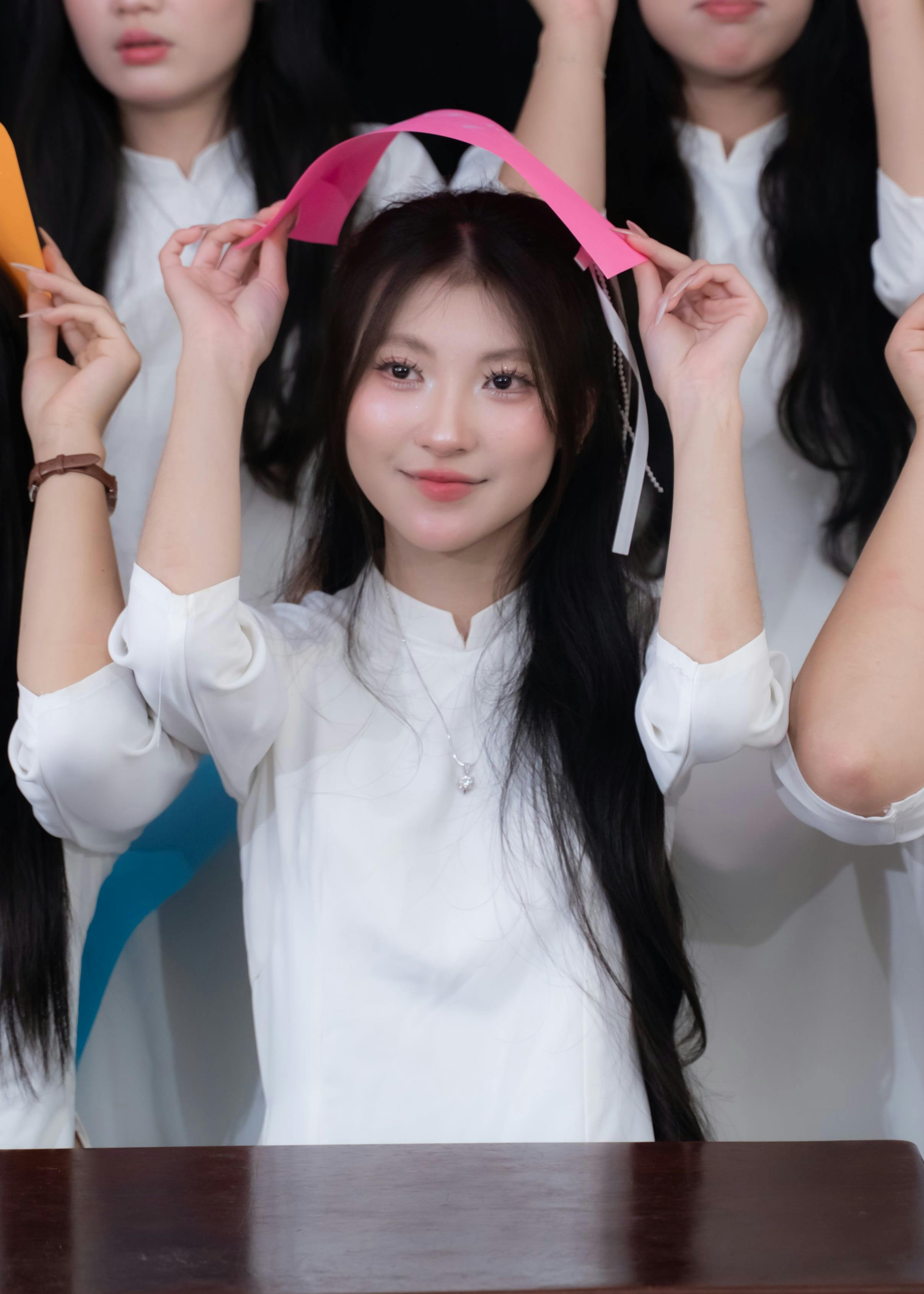 無料 白いドレスを着てピンクの紙帽子を持っている若い女性の肖像写真（室内）。 写真素材