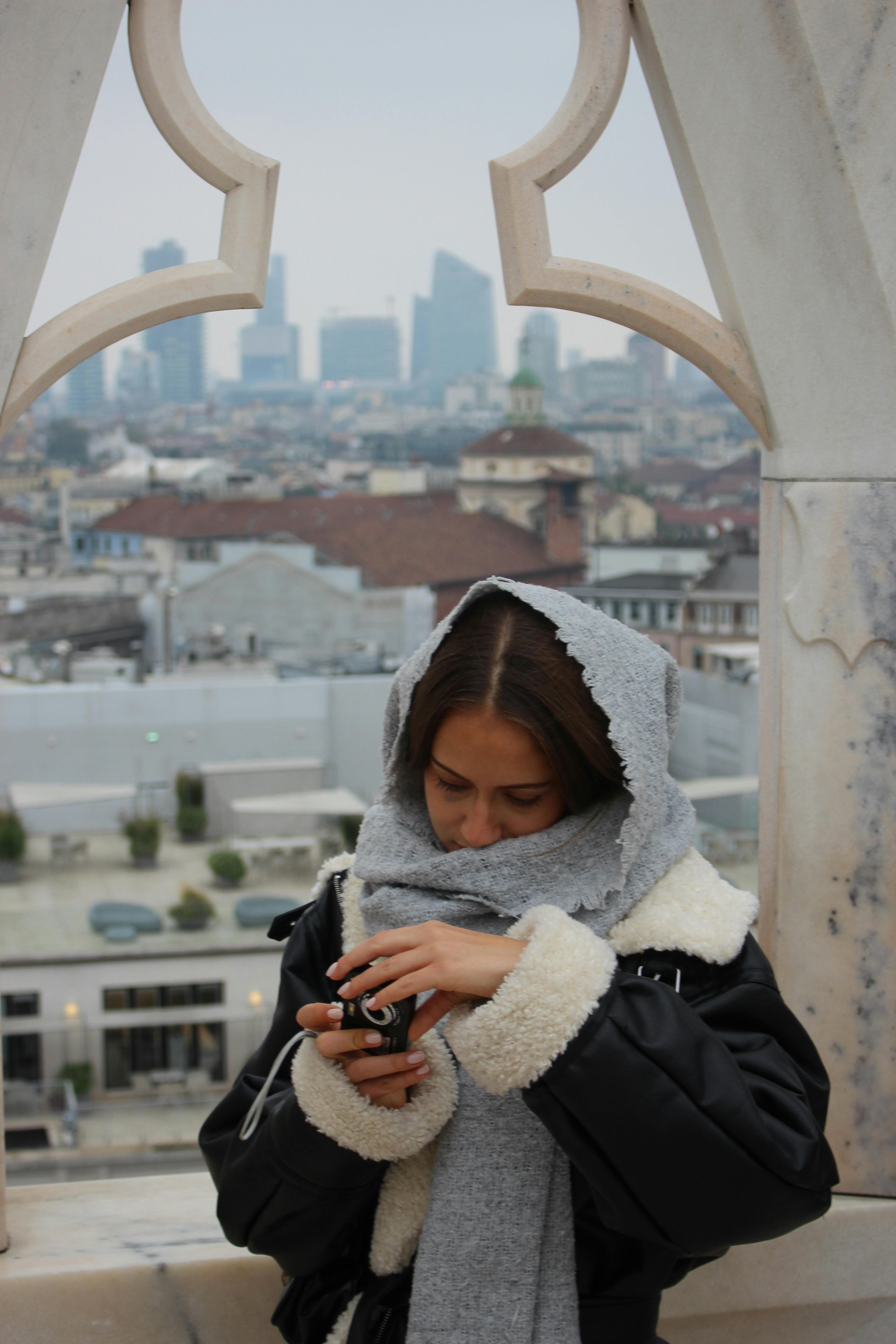 Δωρεάν Μια γυναίκα απολαμβάνει τη θέα από την ταράτσα του καθεδρικού ναού Duomo di Milano, απαθανατίζοντας τον ορίζοντα του Μιλάνου. Φωτογραφία από στοκ φωτογραφιών