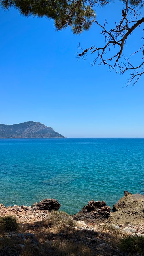 Free Breathtaking view of the Mediterranean coastline featuring clear turquoise waters and distant mountains under a clear blue sky. Stock Photo