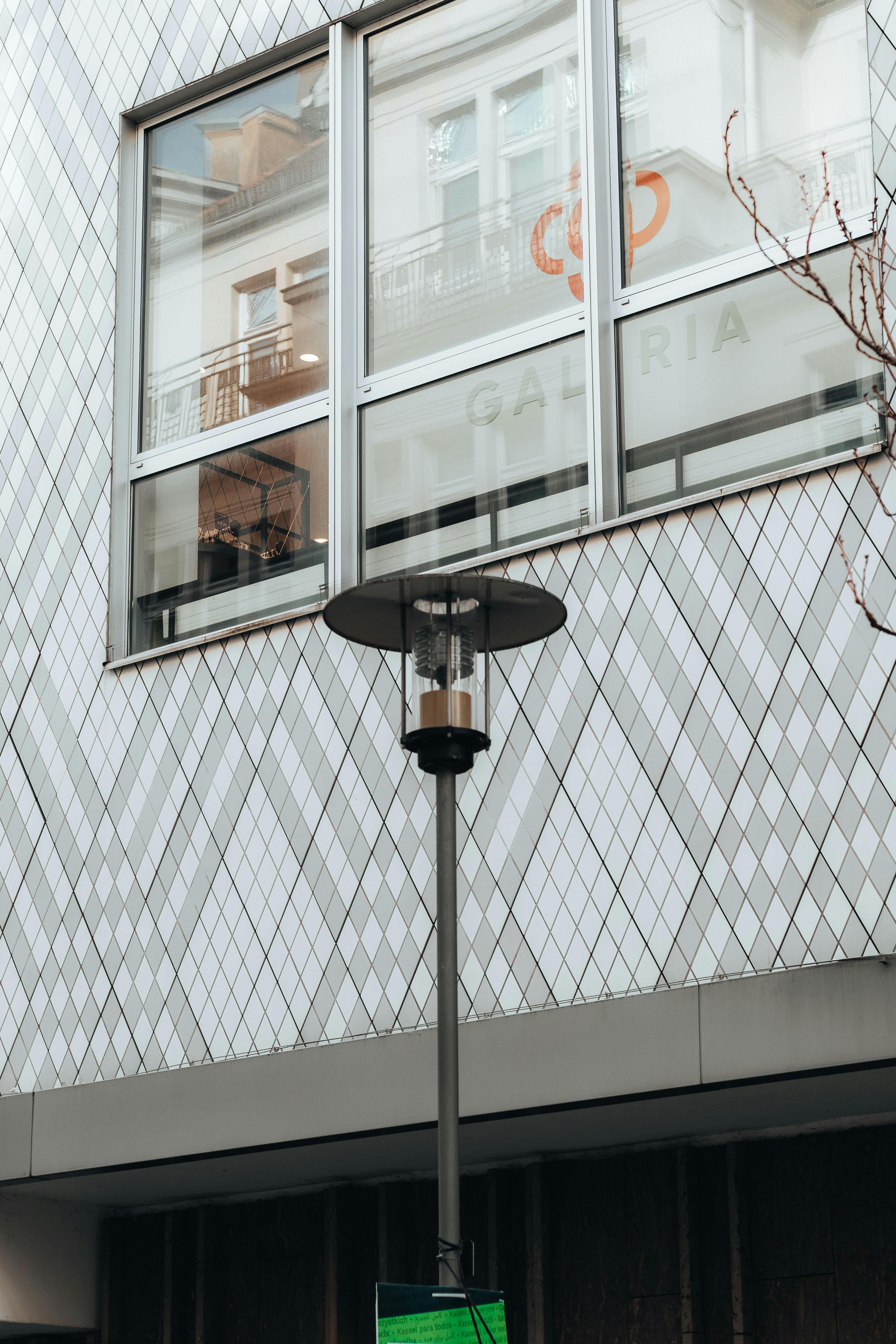 Kostenlos Detailansicht einer modernen Gebäudefassade in Kassel, Deutschland, mit geometrischen Mustern und einer Straßenlaterne. Stock-Foto